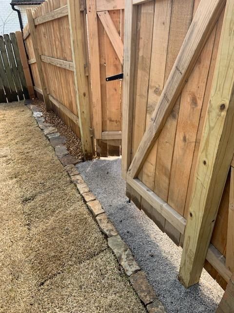 A wooden fence with a gate that is open