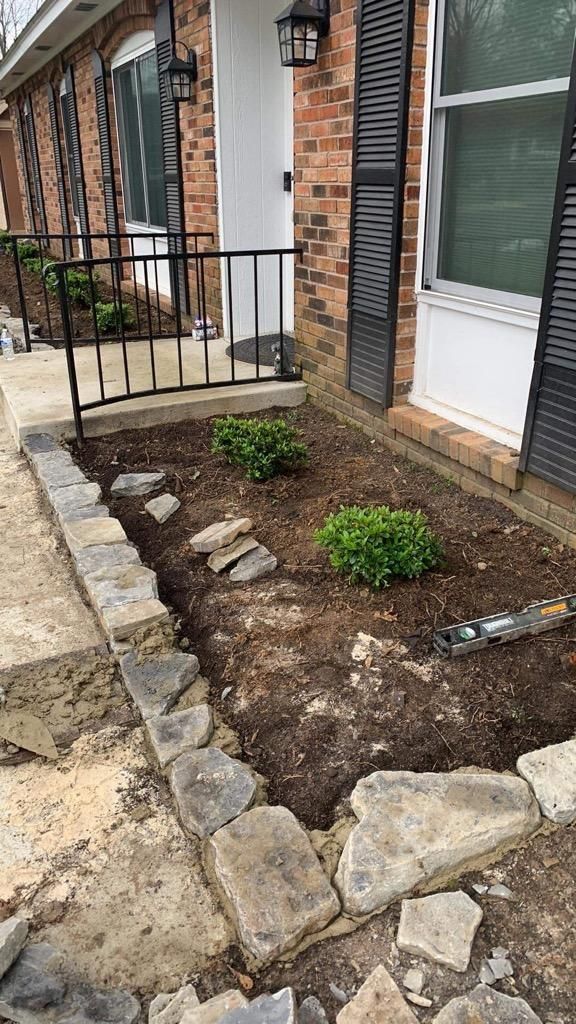 A brick house with a rock garden in front of it.