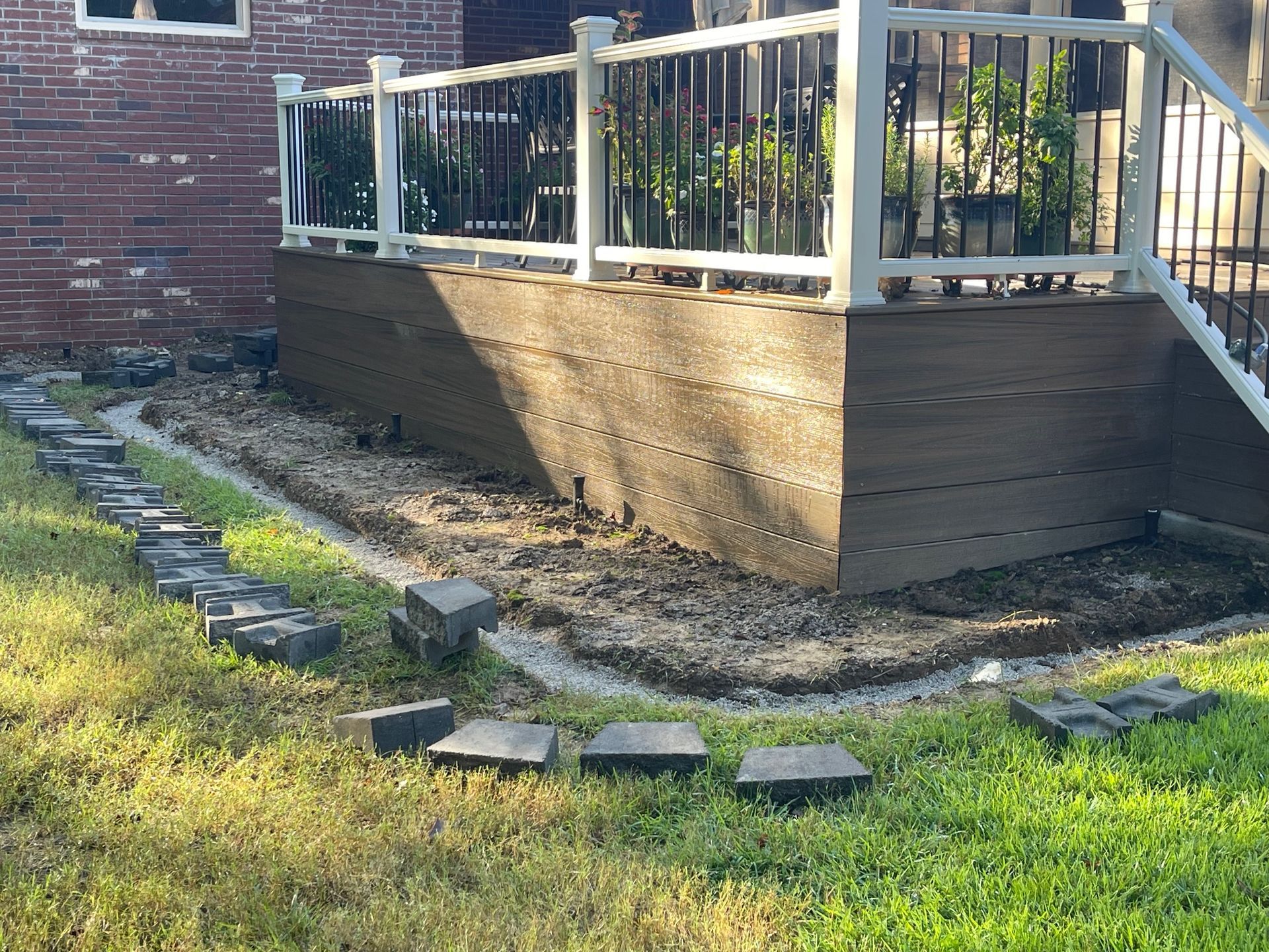 Composite deck skirting with pathway stones and brick house.