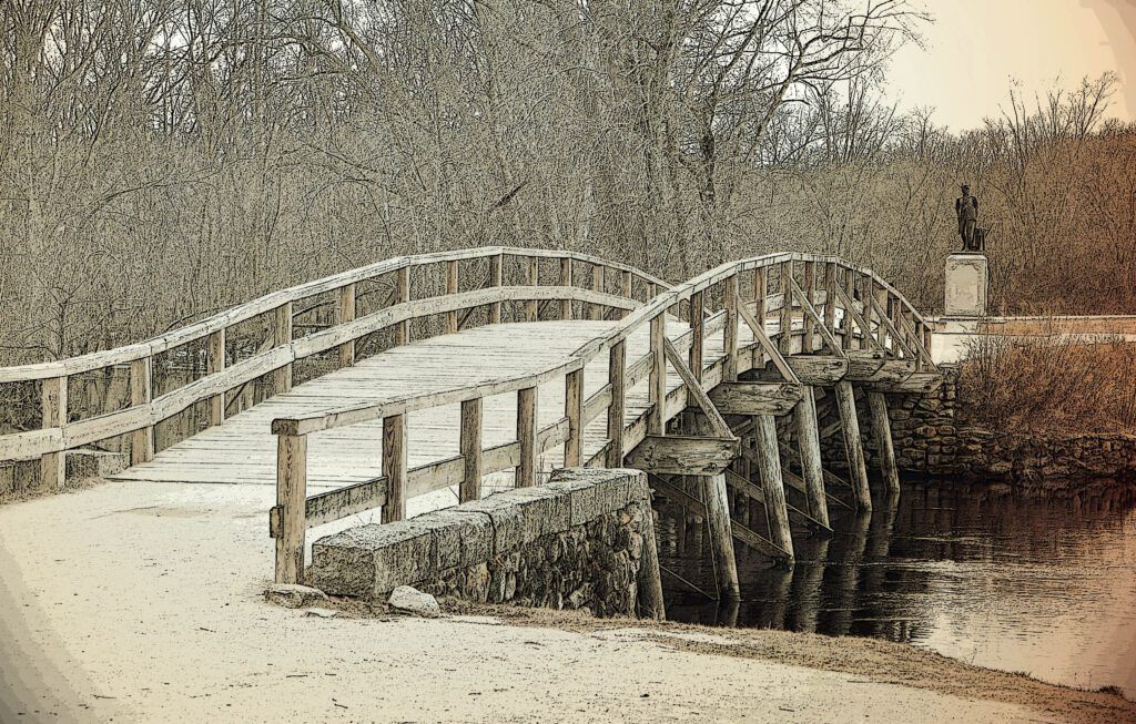 a bridge over a river with a statue in the background