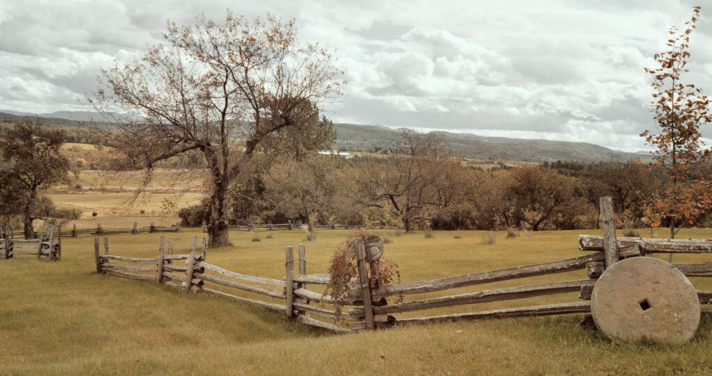 a wooden fence in a field with mountains in the background in Shoreham, VT
