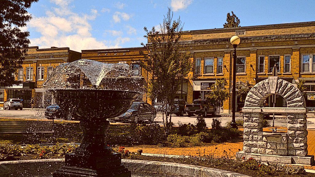a fountain in front of a brick building with a sign that says ' abercrombie & fitch ' on it in Brandon, VT