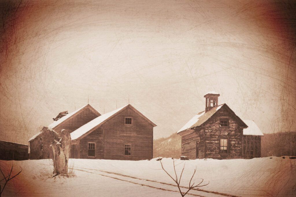 a sepia toned photo of two houses in the snow