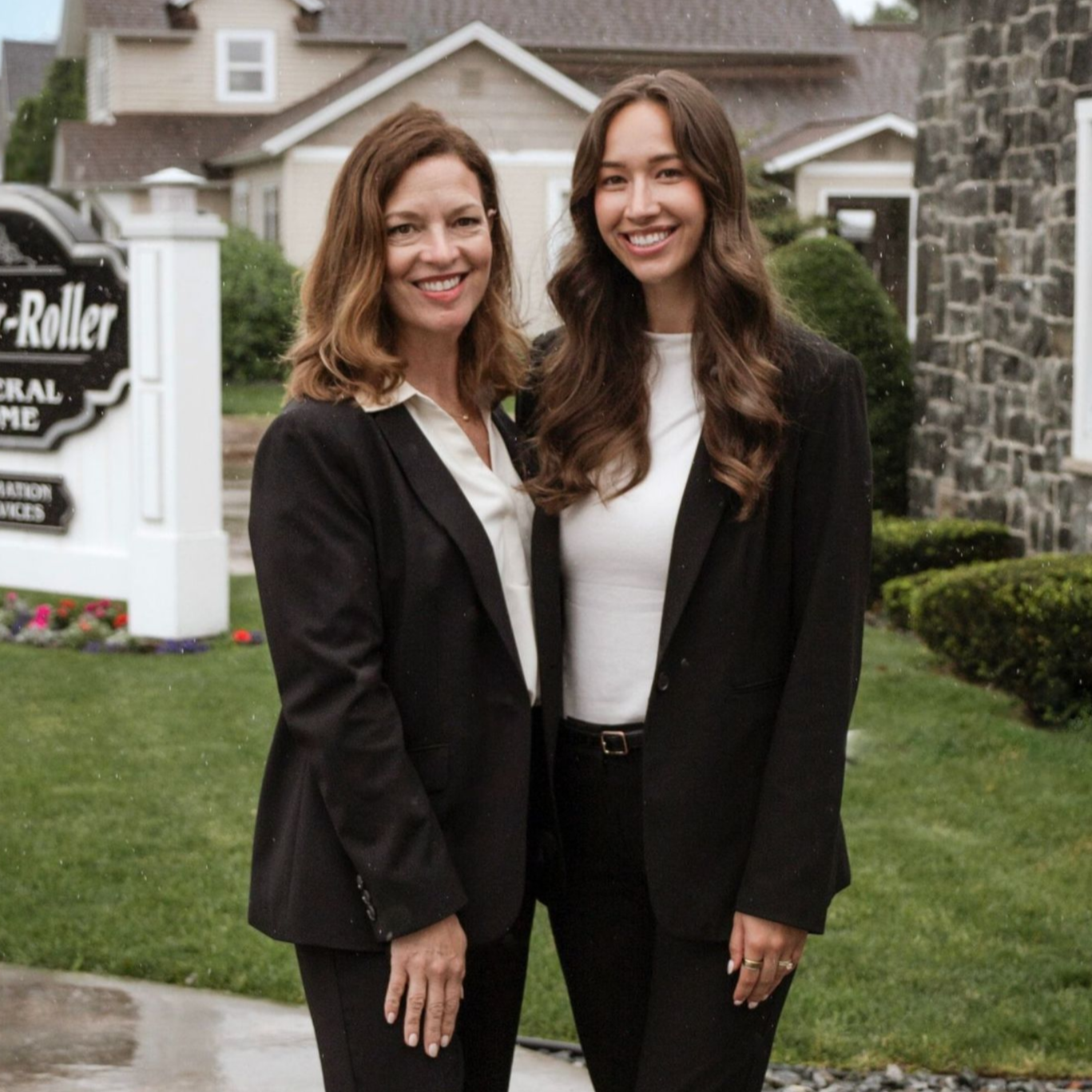 A woman wearing hoop earrings and a white shirt is smiling for the camera.
