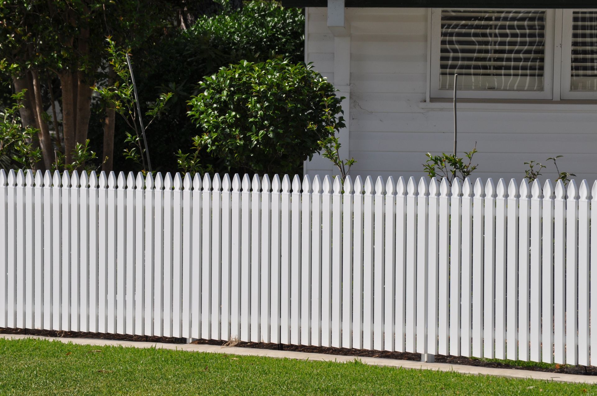A white picket fence is in front of a white house — Fabricator In Coffs Harbour, NSW