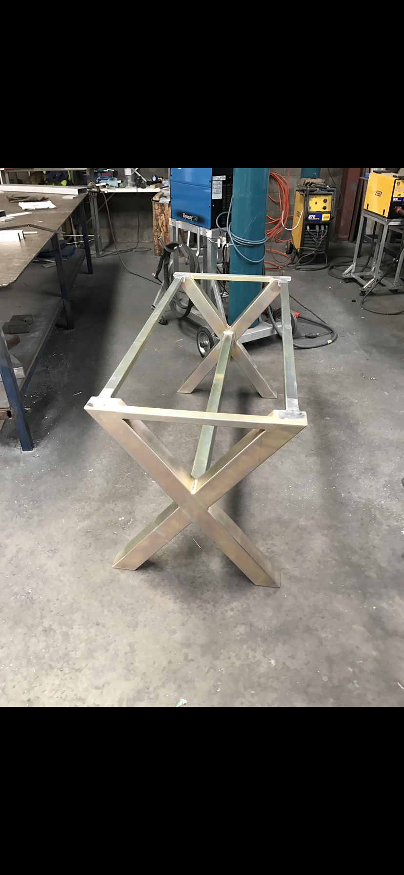 A wooden table frame is sitting on the floor in a workshop — Fabricator In Coffs Harbour, NSW