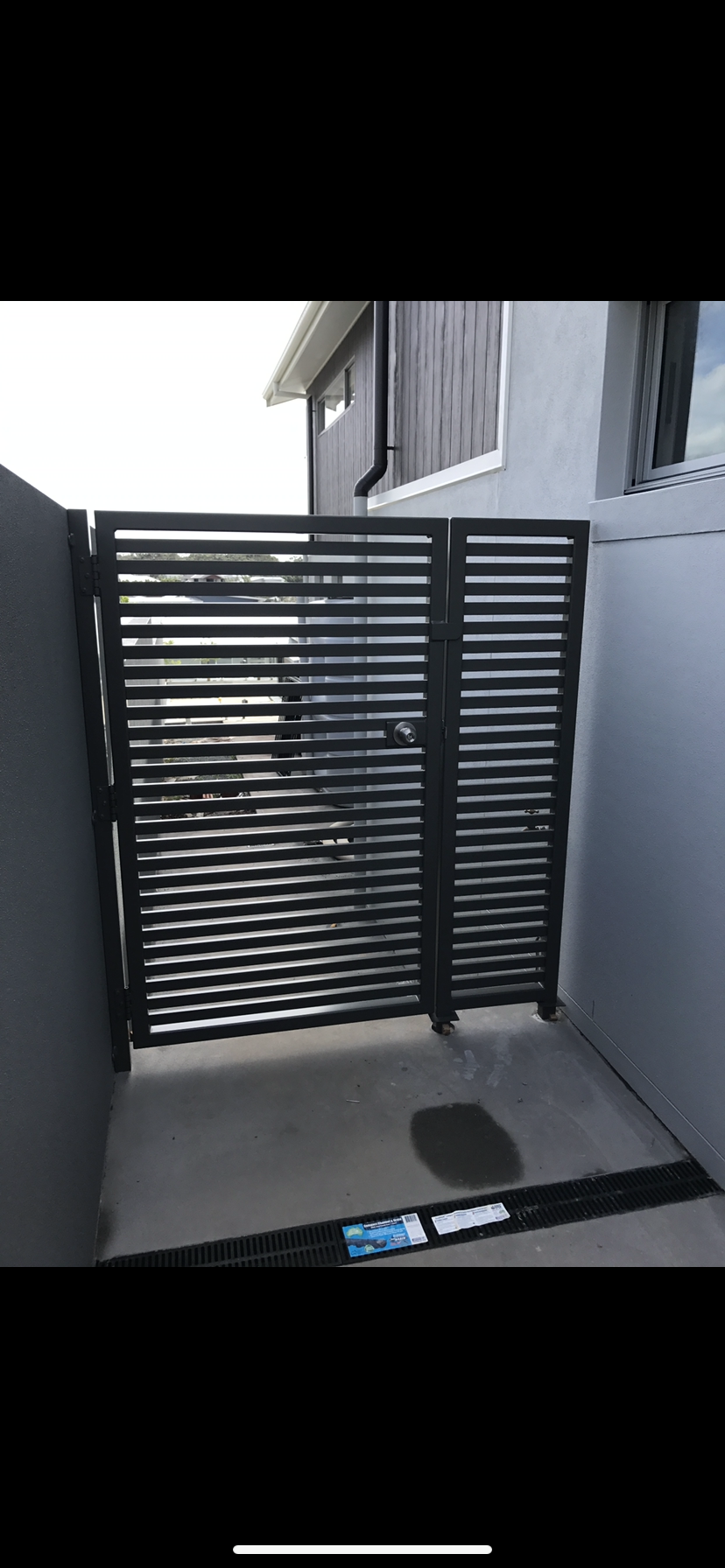 A black gate is sitting in front of a building — Fabricator In Coffs Harbour, NSW
