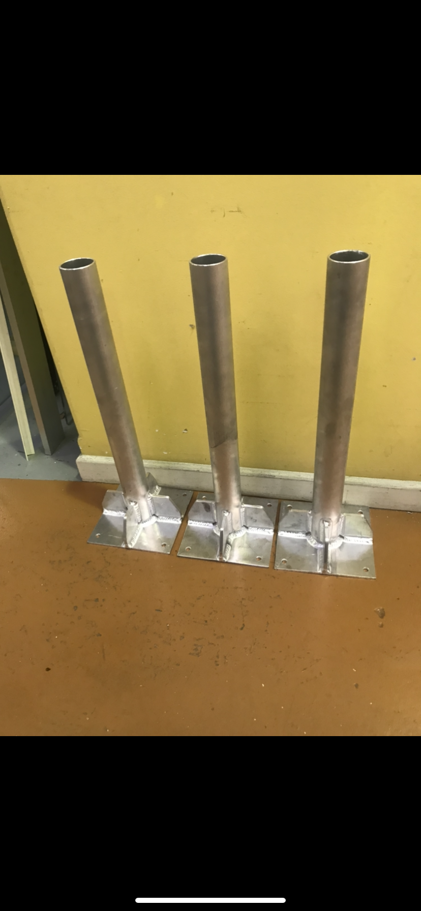 Three stainless steel vases are sitting on a wooden floor — Fabricator In Coffs Harbour, NSW