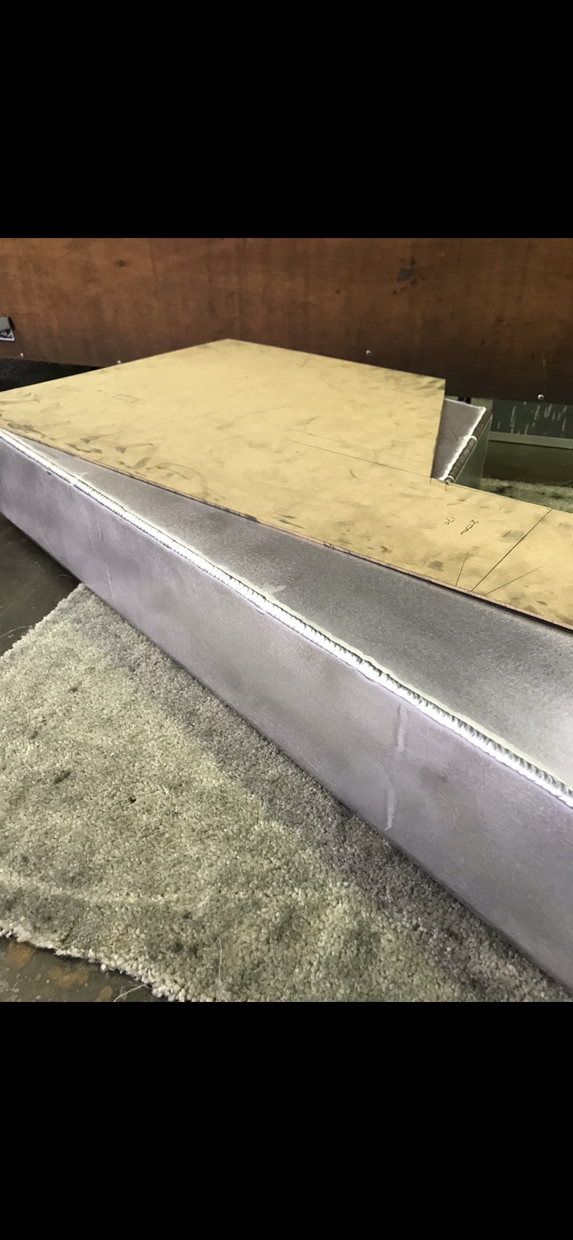 A piece of metal is sitting on top of a piece of wood — Fabricator In Coffs Harbour, NSW