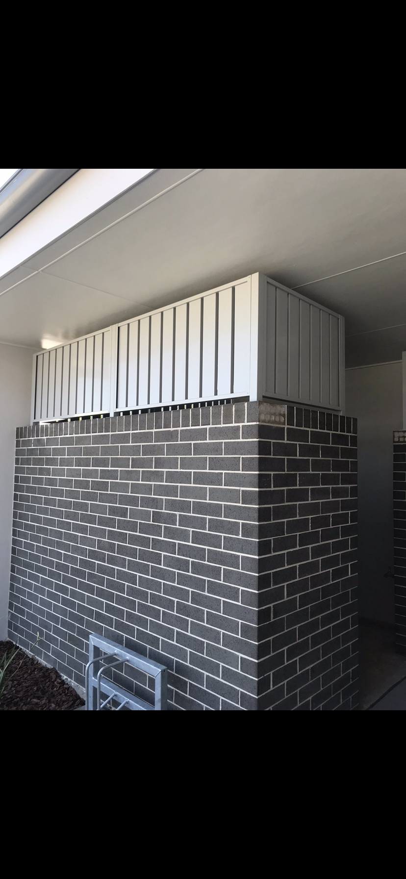 A brick wall with a white fence on top of it — Fabricator In Coffs Harbour, NSW