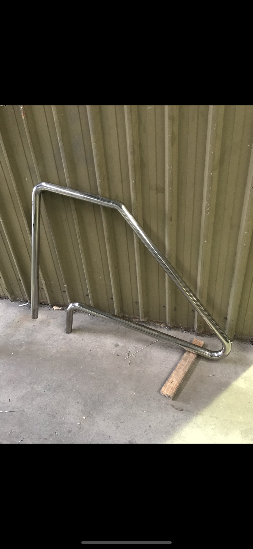 A metal railing is sitting on the ground in front of a wall — Fabricator In Coffs Harbour, NSW