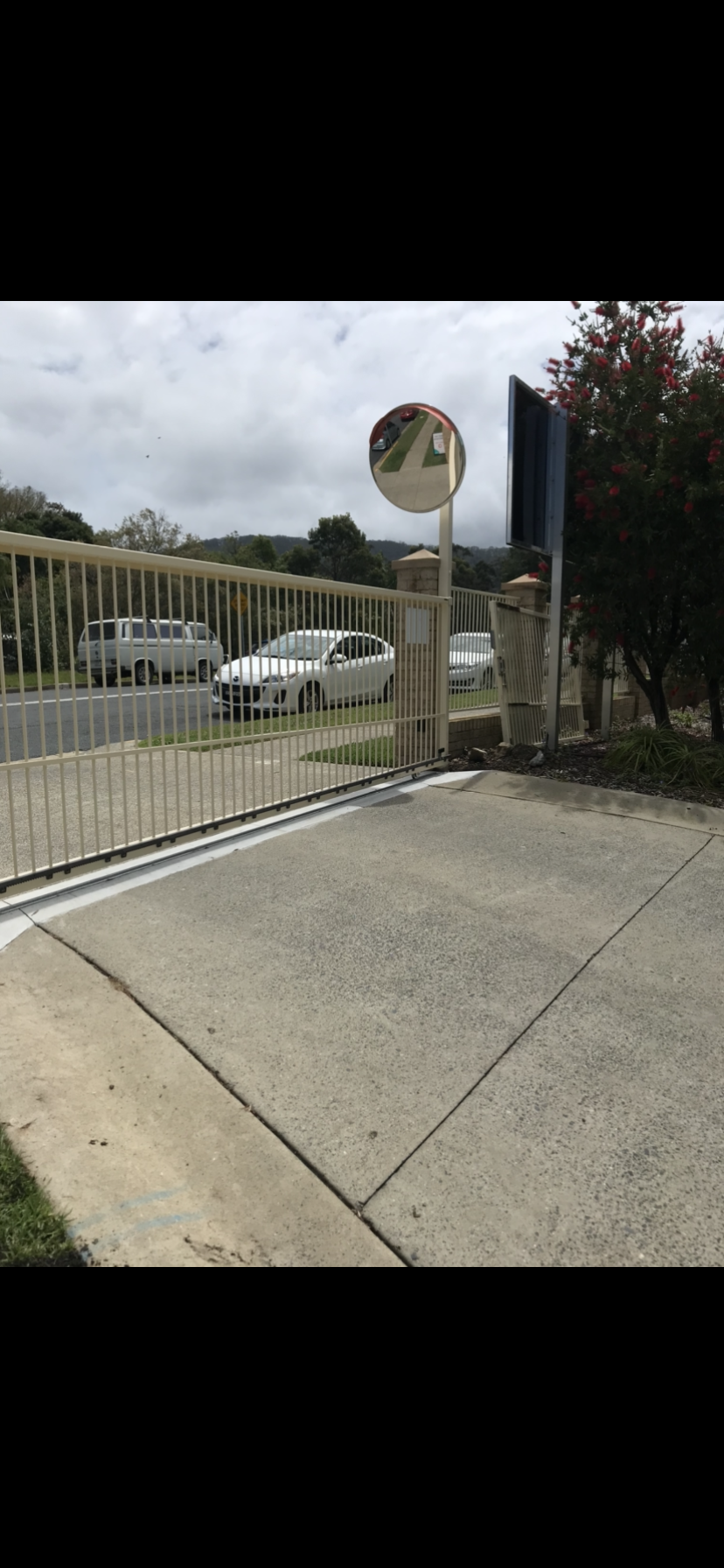 A parking lot with cars parked in front of a fence and a mirror. — Fabricator In Coffs Harbour, NSW