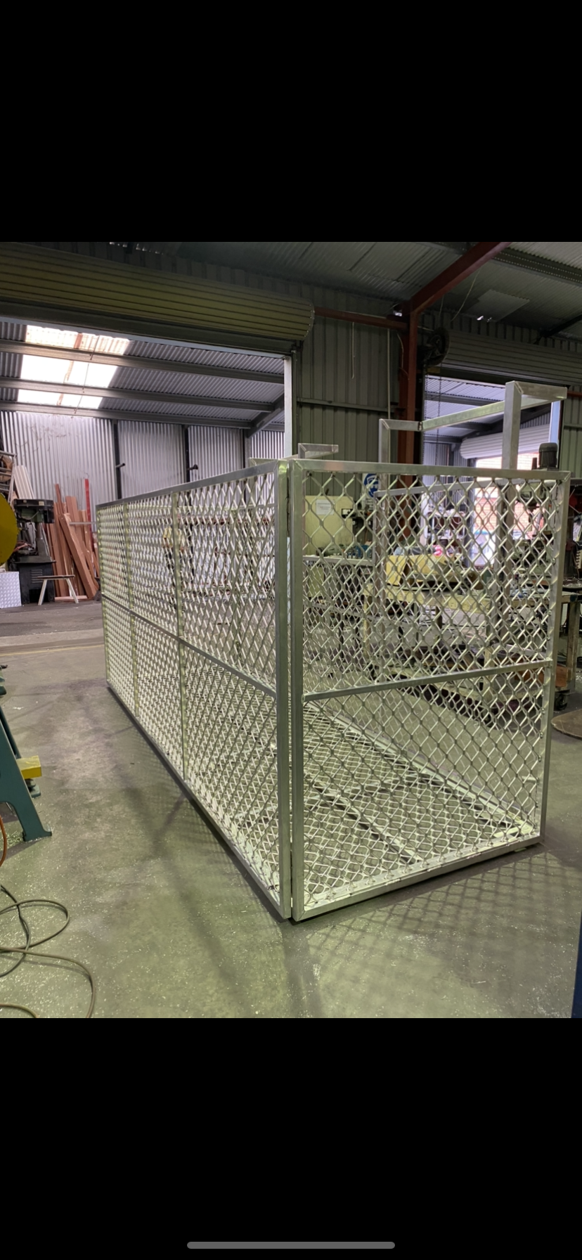 A large metal cage is sitting in a warehouse — Fabricator In Coffs Harbour, NSW