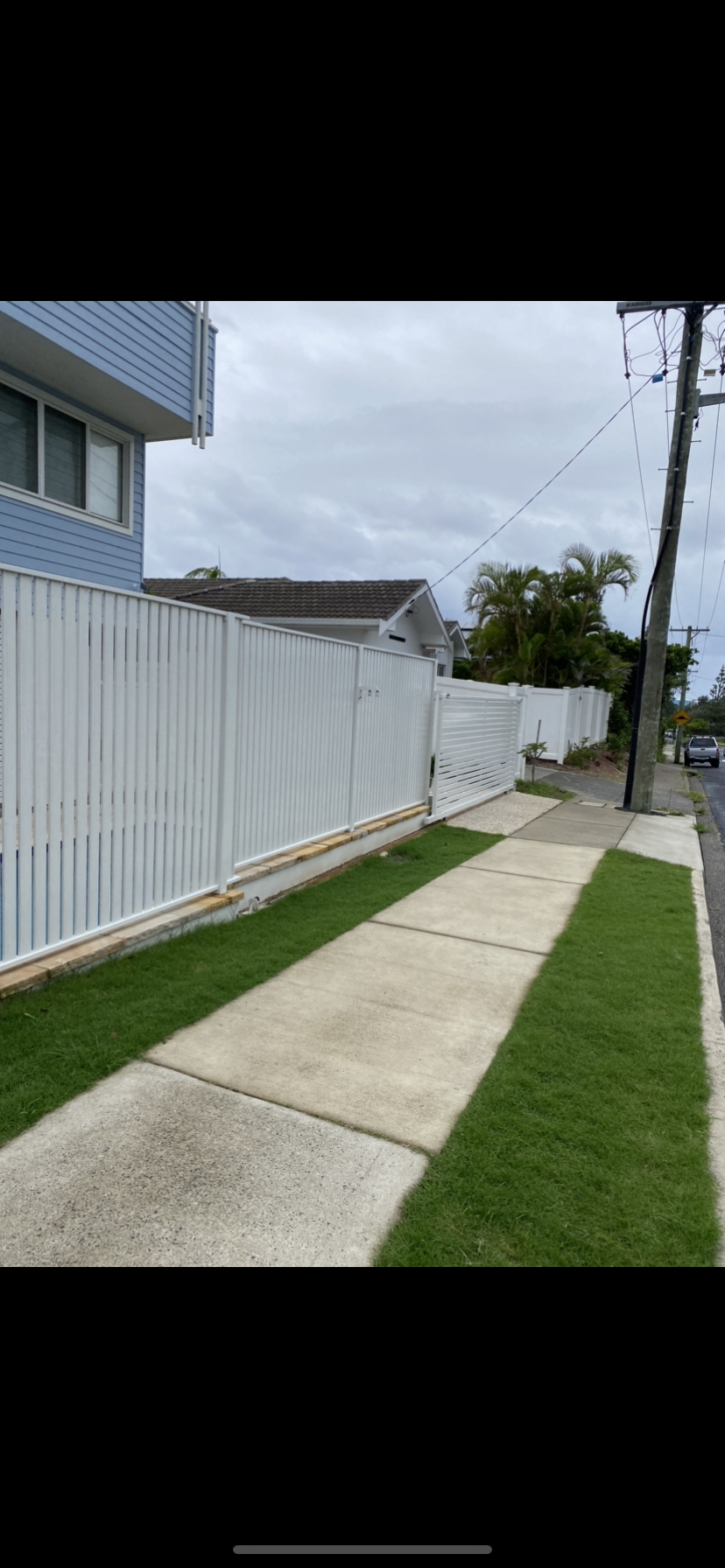 A white fence along a sidewalk next to a house — Fabricator In Coffs Harbour, NSW