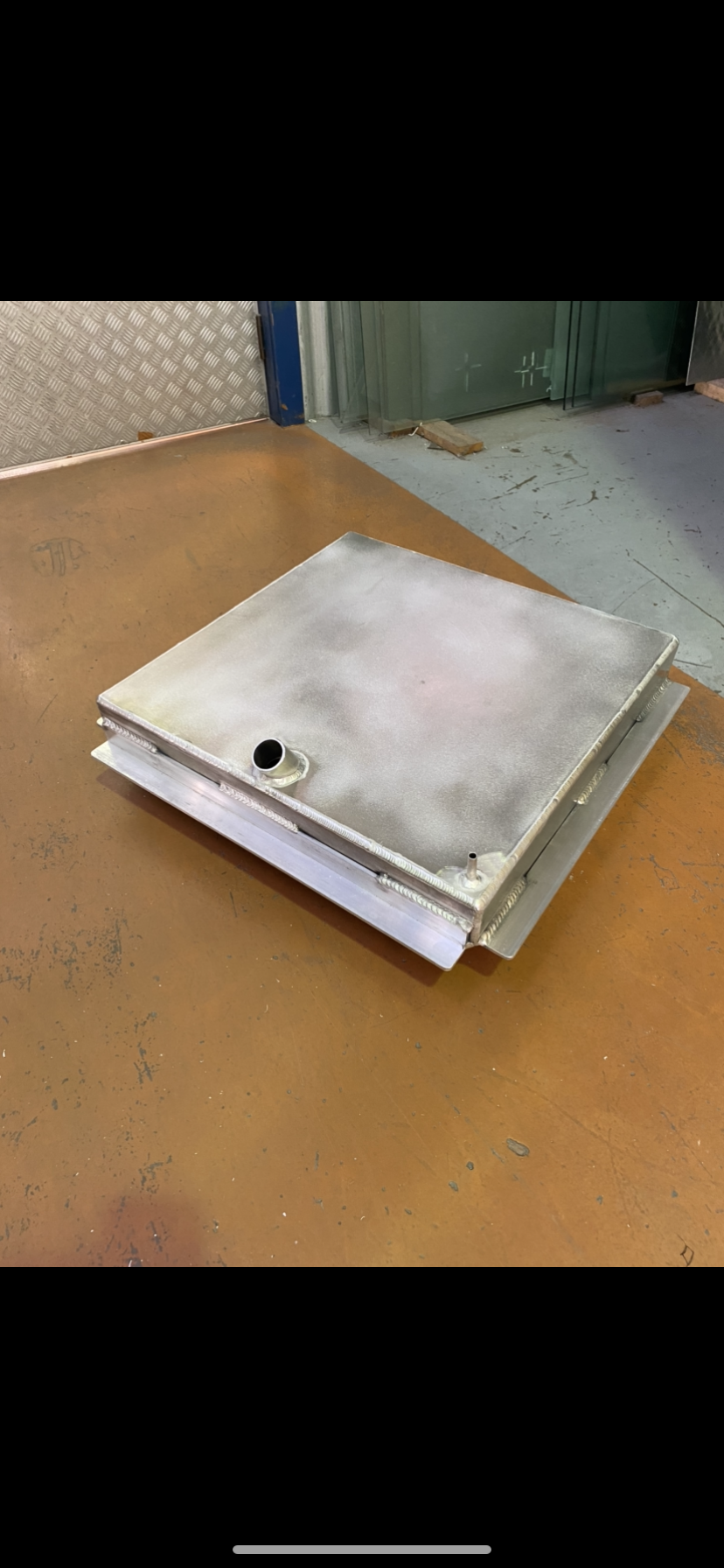 A piece of metal is sitting on top of a wooden table — Fabricator In Coffs Harbour, NSW