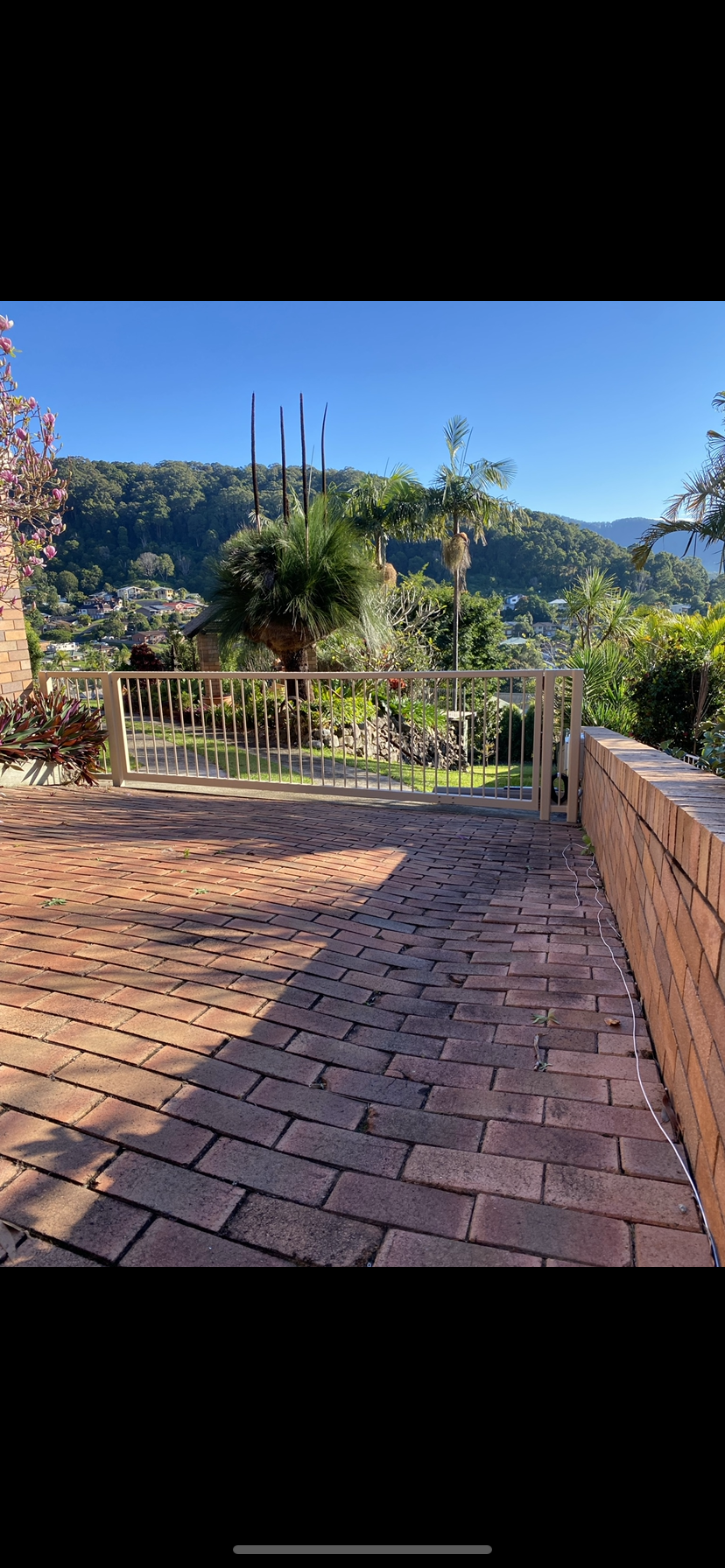 A brick walkway leading to a fence with mountains in the background — Fabricator In Coffs Harbour, NSW