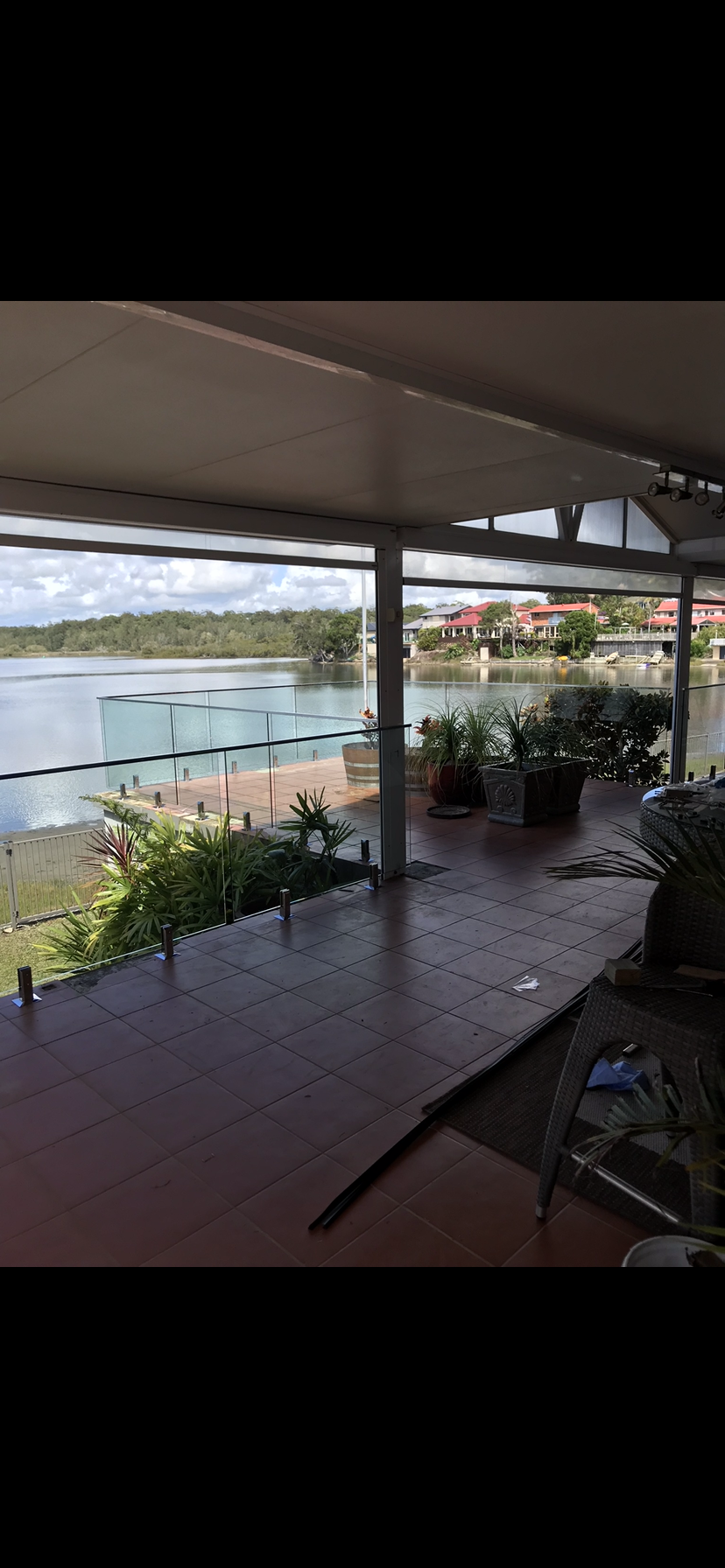 A view of a lake from a balcony with a glass railing — Fabricator In Coffs Harbour, NSW