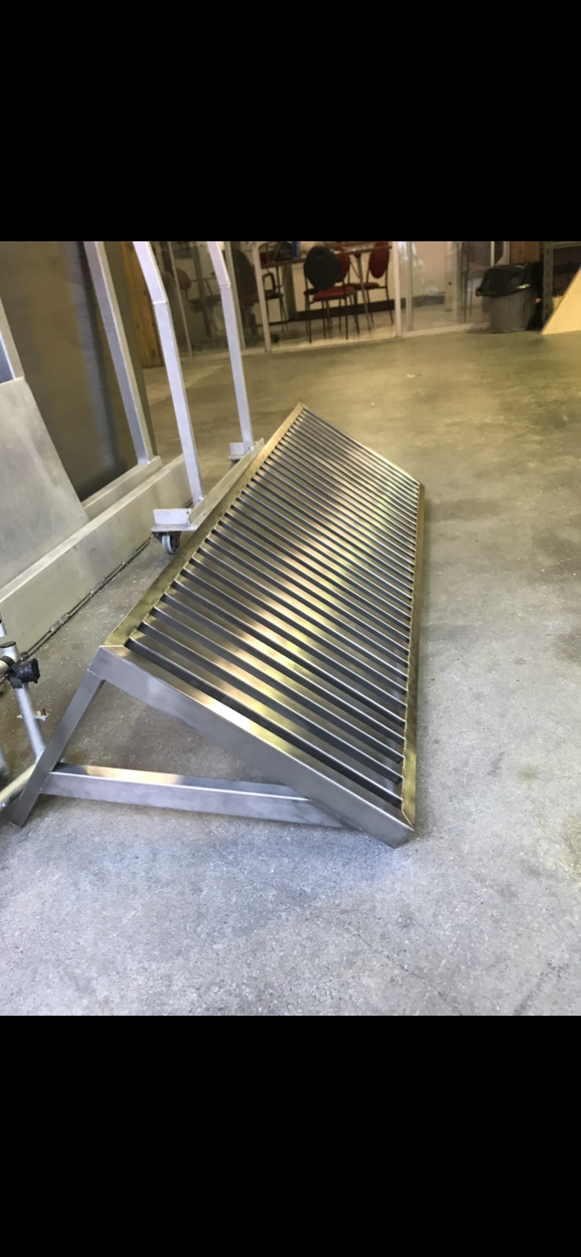 A stainless steel ramp is sitting on the floor in a room — Fabricator In Coffs Harbour, NSW