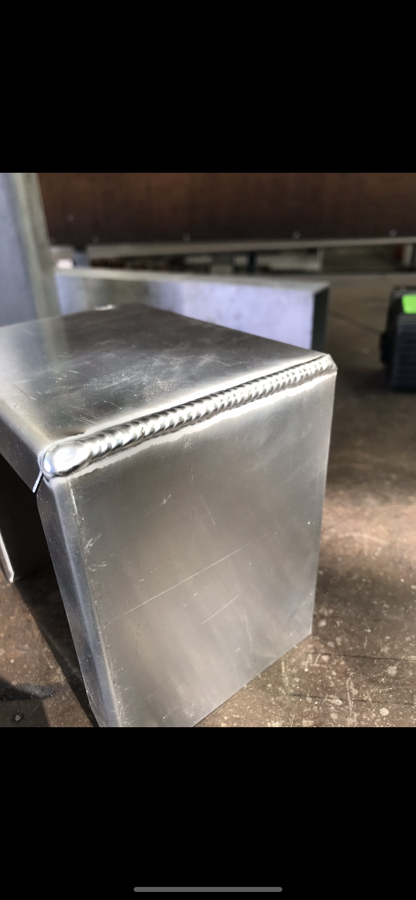 A stainless steel box is sitting on top of a wooden table — Fabricator In Coffs Harbour, NSW