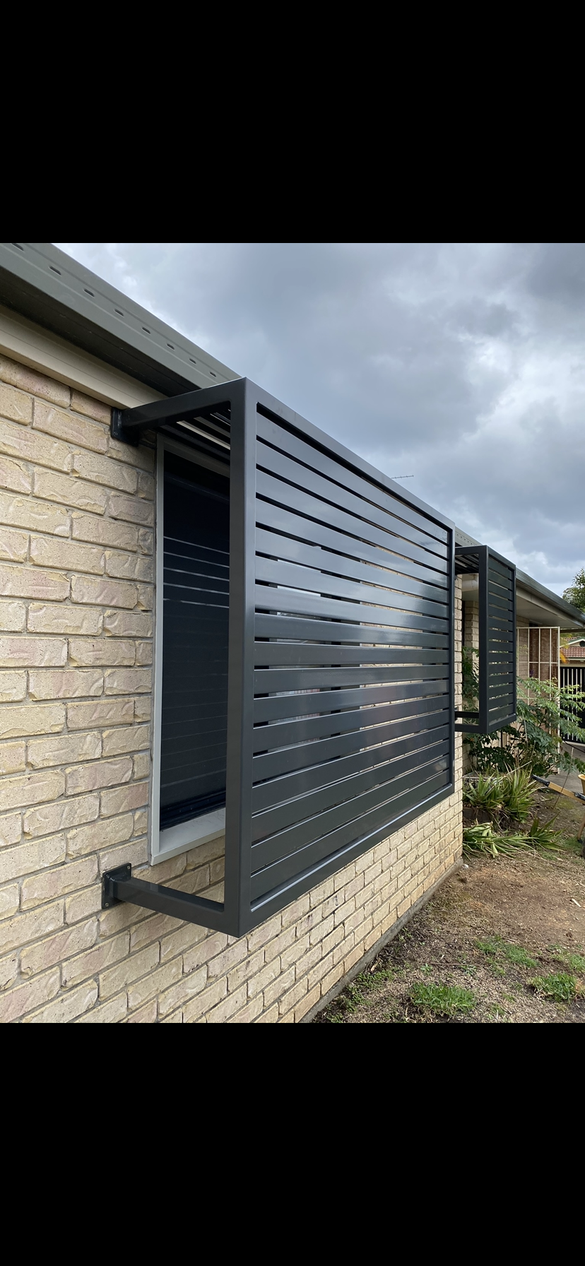 A brick building with a window covered in a fence — Fabricator In Coffs Harbour, NSW
