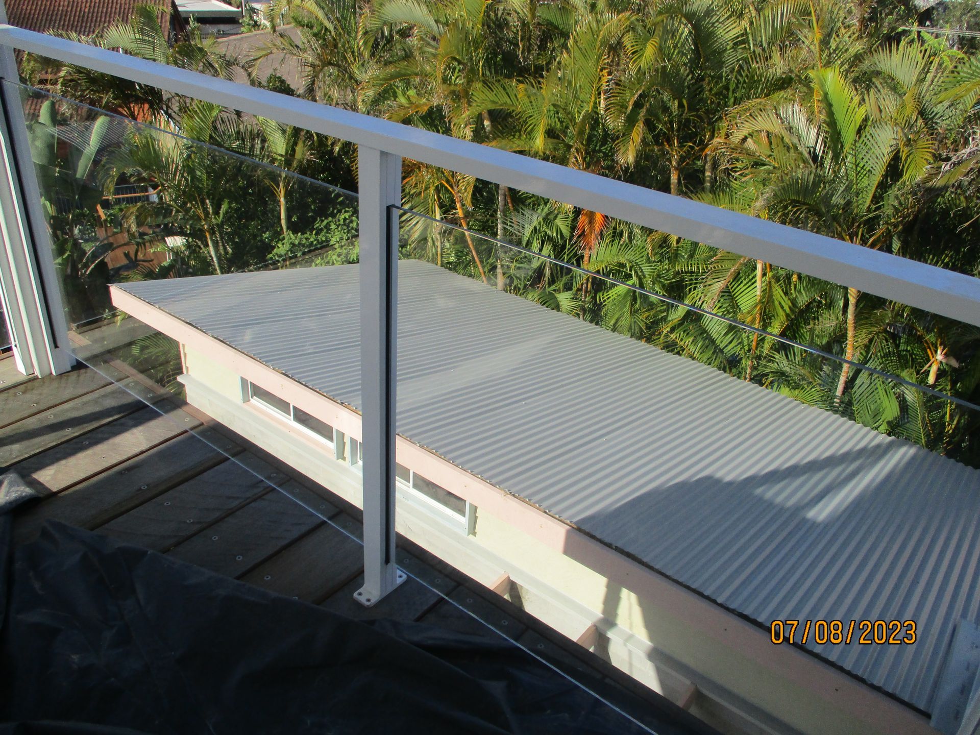 A balcony with a white railing and a roof with trees in the background — Fabricator In Coffs Harbour, NSW