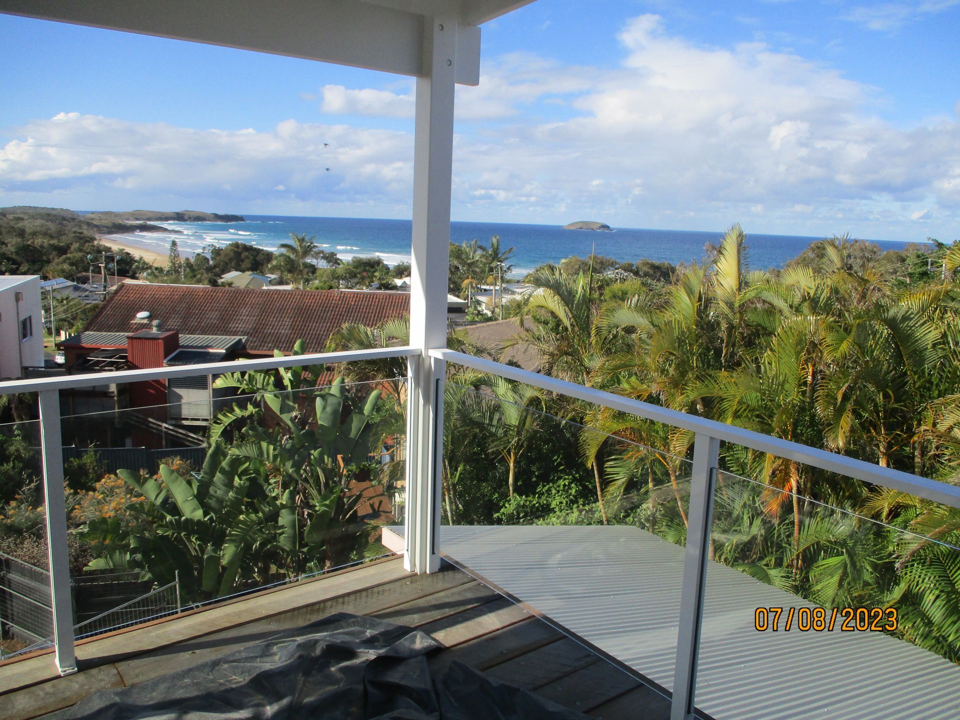 A balcony with a view of the ocean and palm trees — Fabricator In Coffs Harbour, NSW