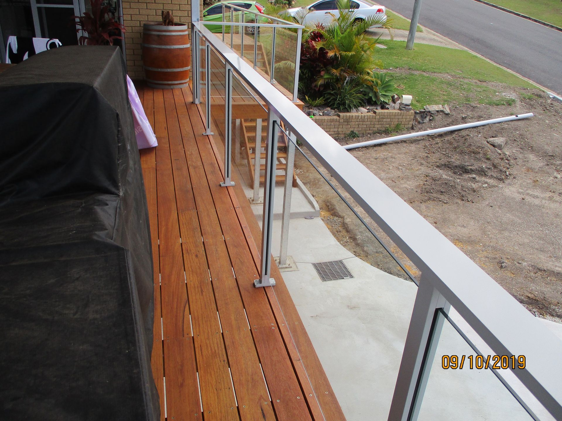 A picture of a wooden deck with a glass railing was taken in 2013 — Fabricator In Coffs Harbour, NSW