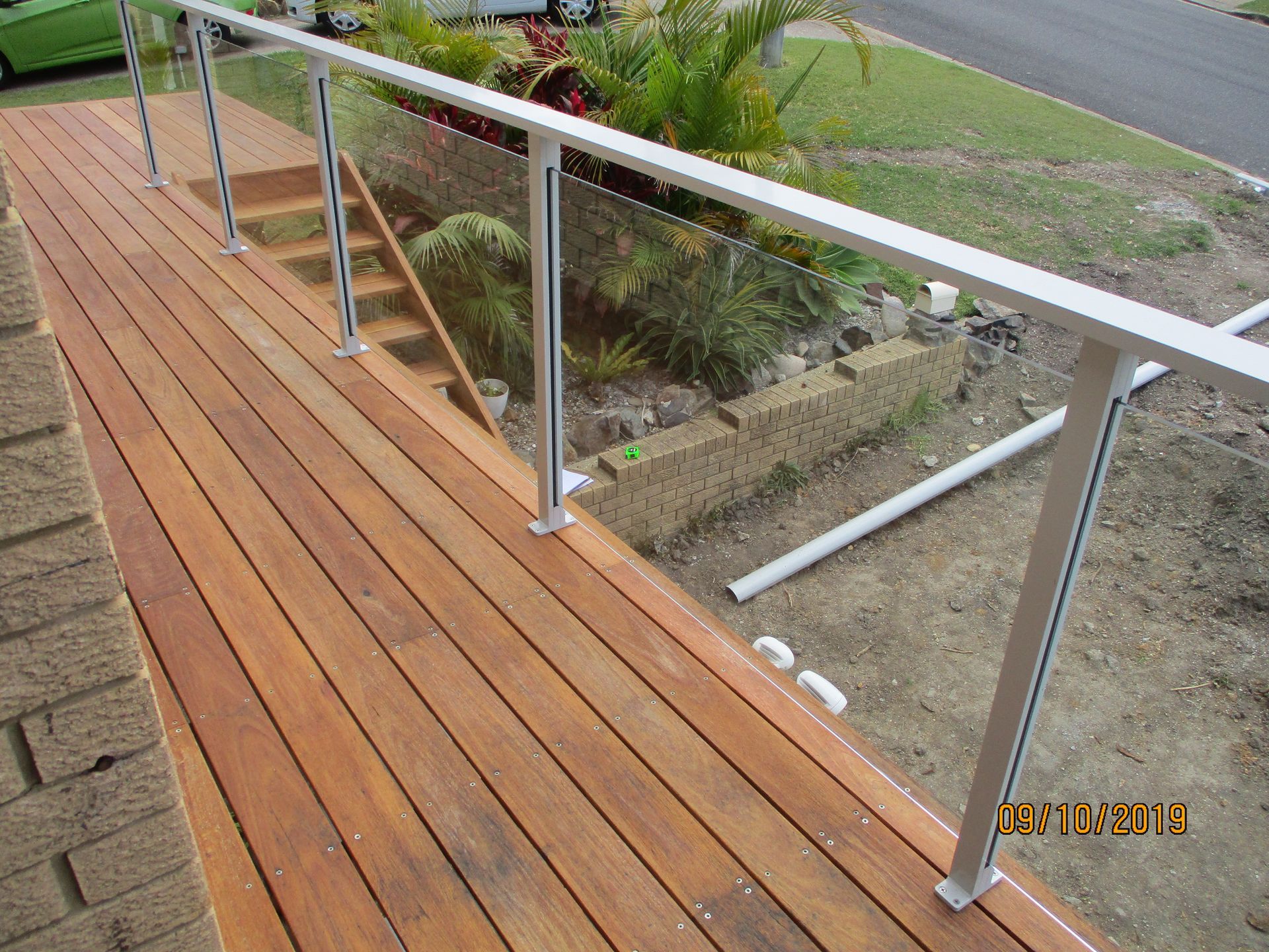 A wooden deck with a glass railing and stairs — Fabricator In Coffs Harbour, NSW