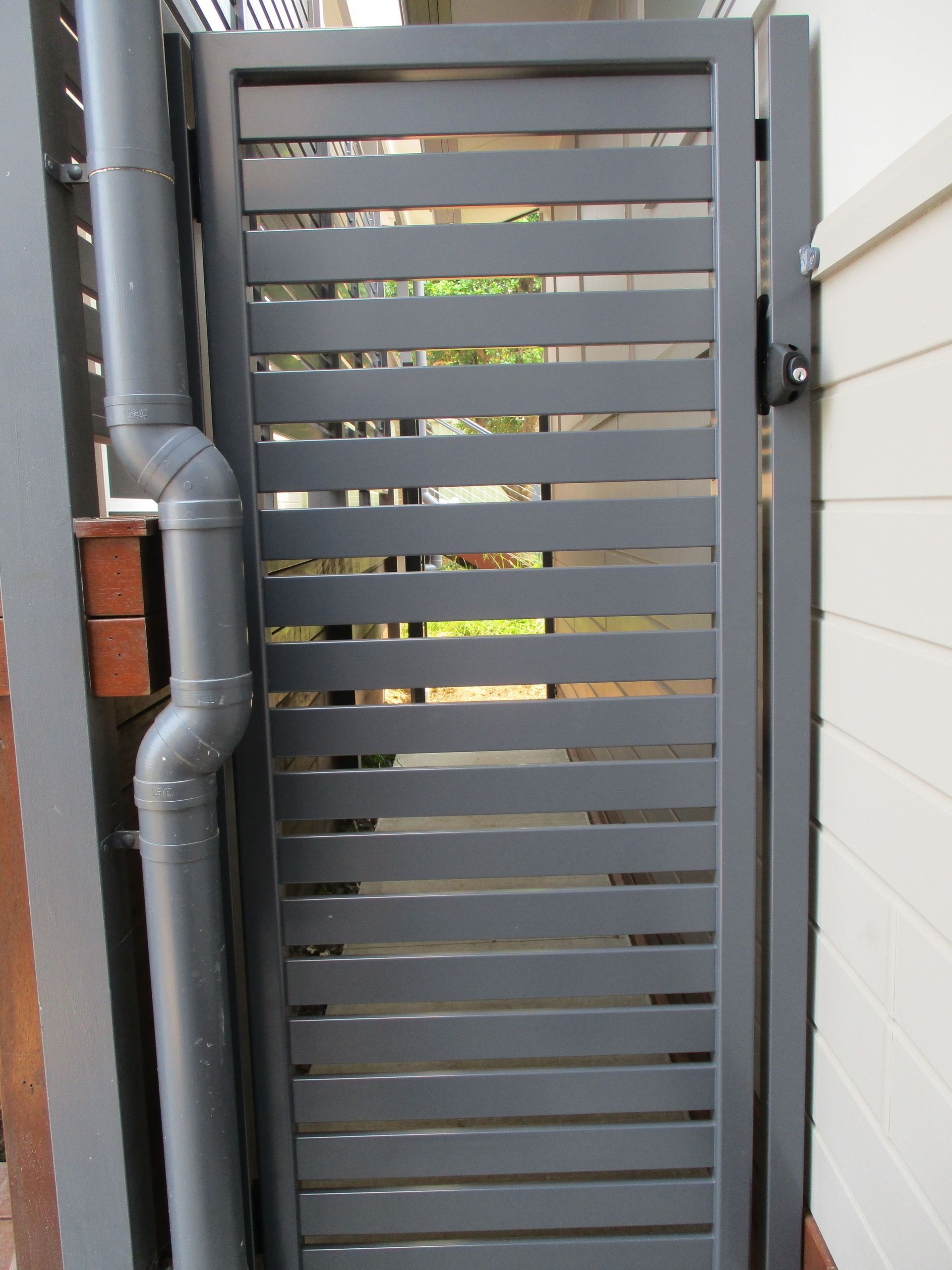 A gray gate with a drain pipe attached to it — Fabricator In Coffs Harbour, NSW
