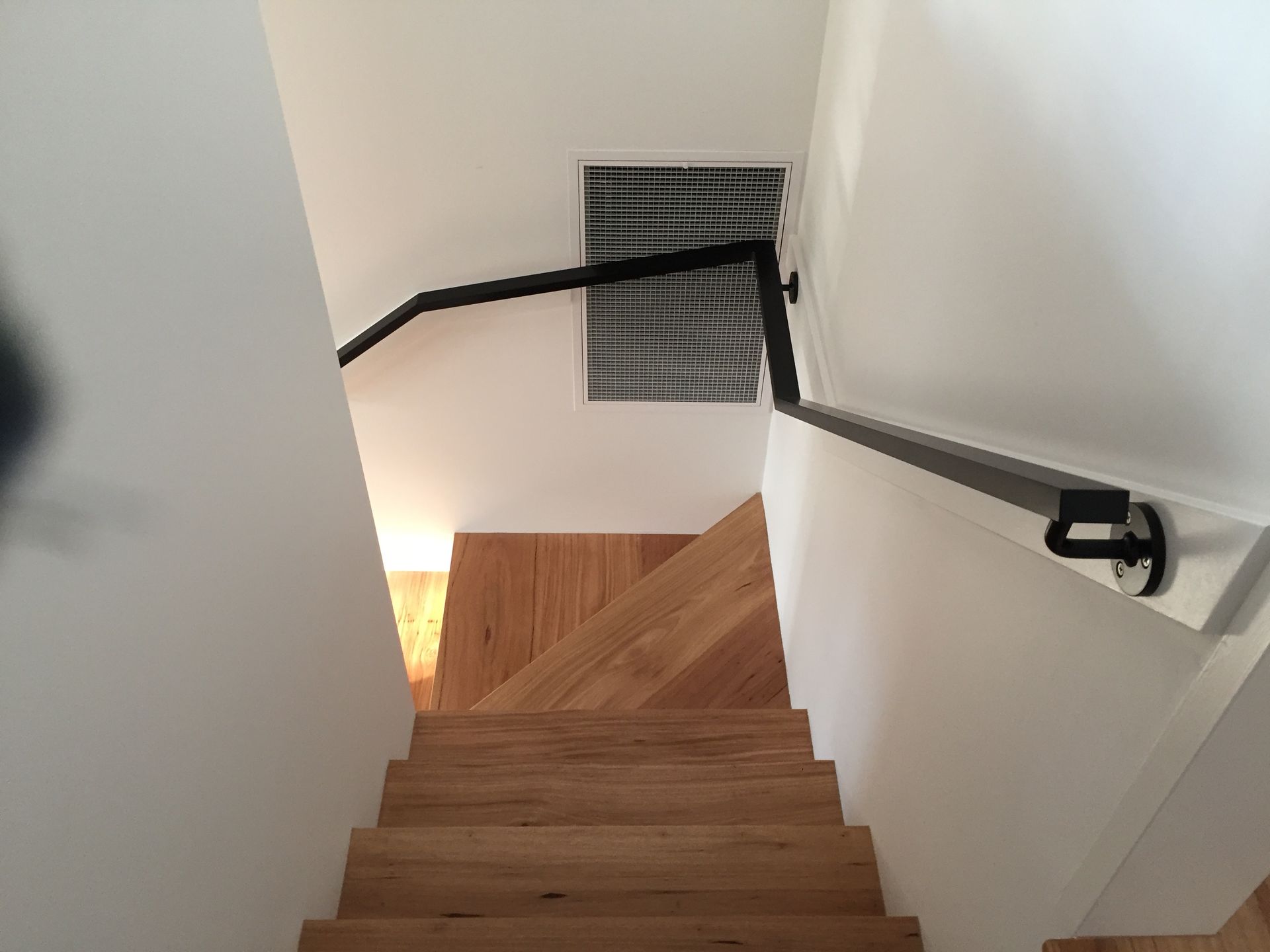 A wooden staircase with a black railing and a window — Fabricator In Coffs Harbour, NSW