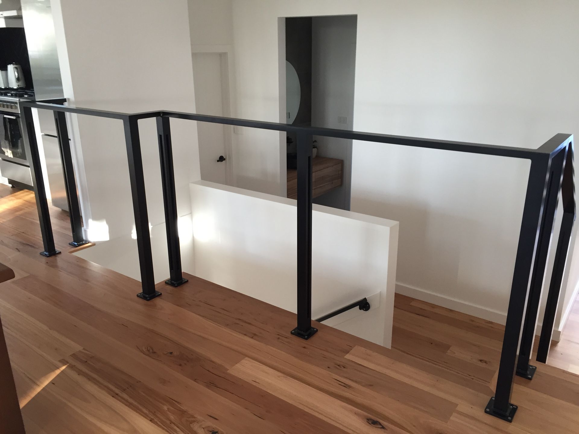 A staircase with a black railing and a wooden floor — Fabricator In Coffs Harbour, NSW