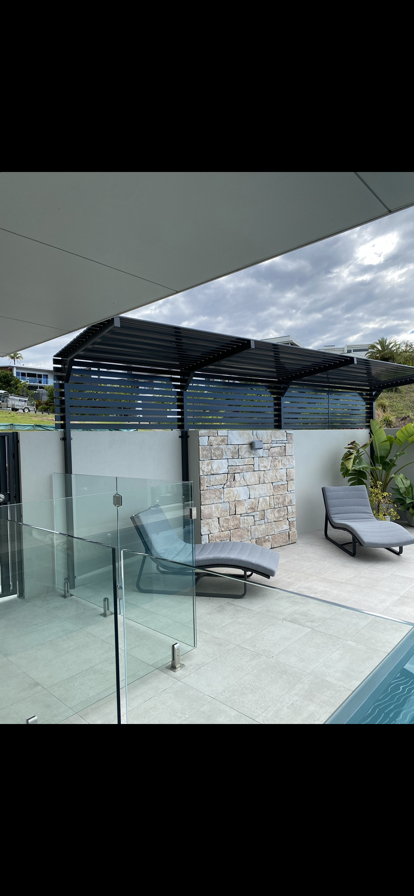 A patio with a swimming pool , chairs and a fence — Fabricator In Coffs Harbour, NSW