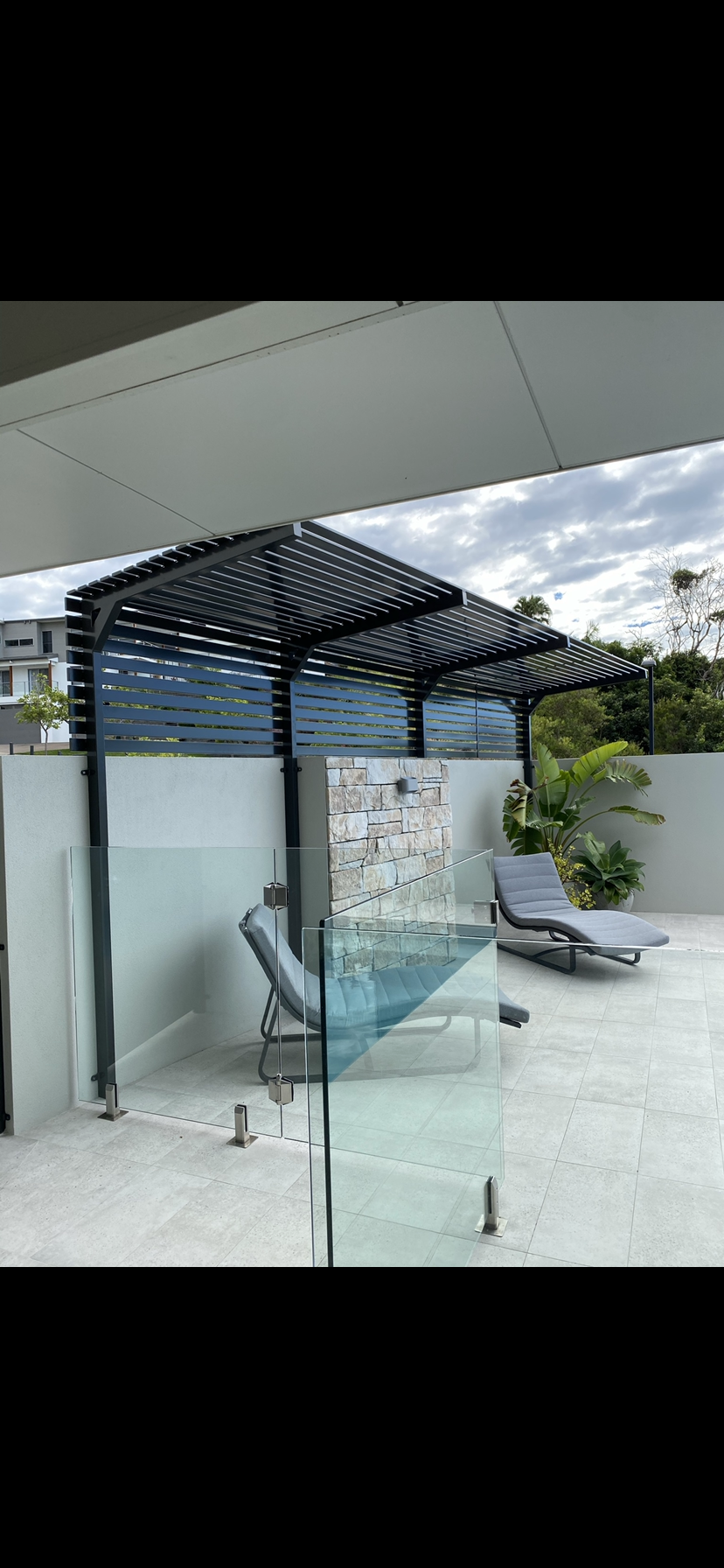 A patio with a pergola , chairs and a pool — Fabricator In Coffs Harbour, NSW