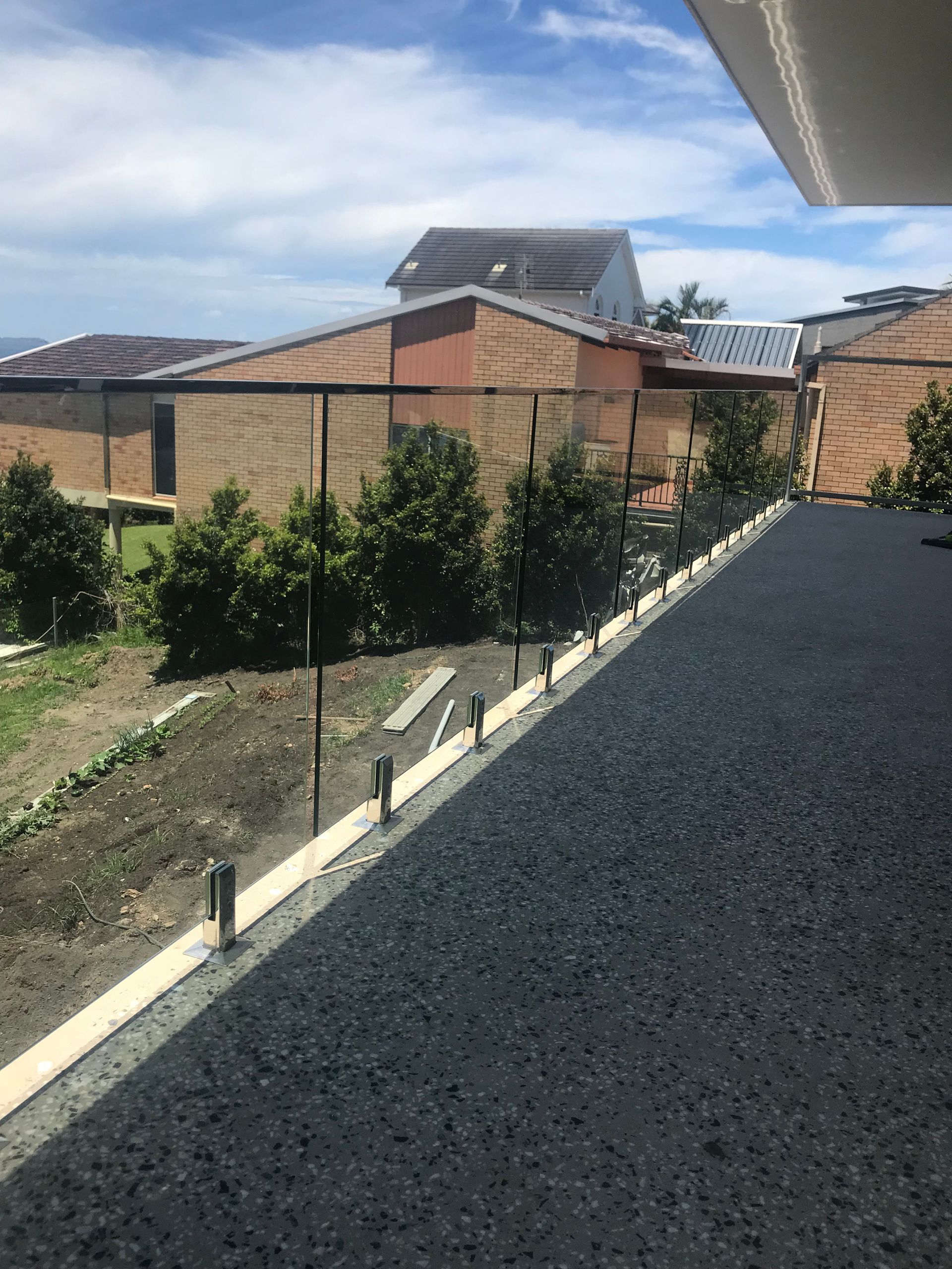 A view of a house from a balcony with a glass railing — Fabricator In Coffs Harbour, NSW