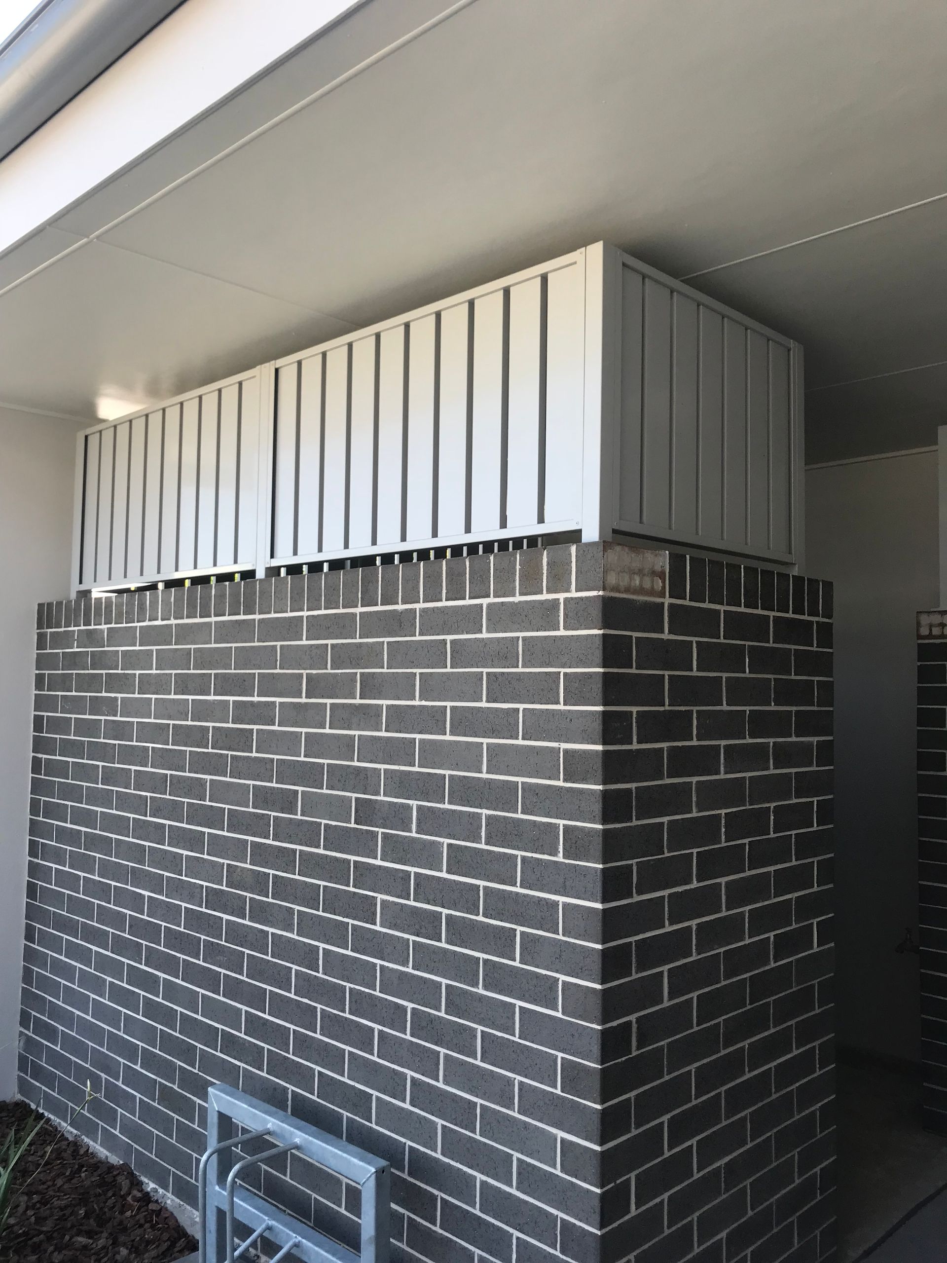 A brick wall with a white railing on top of it — Fabricator In Coffs Harbour, NSW