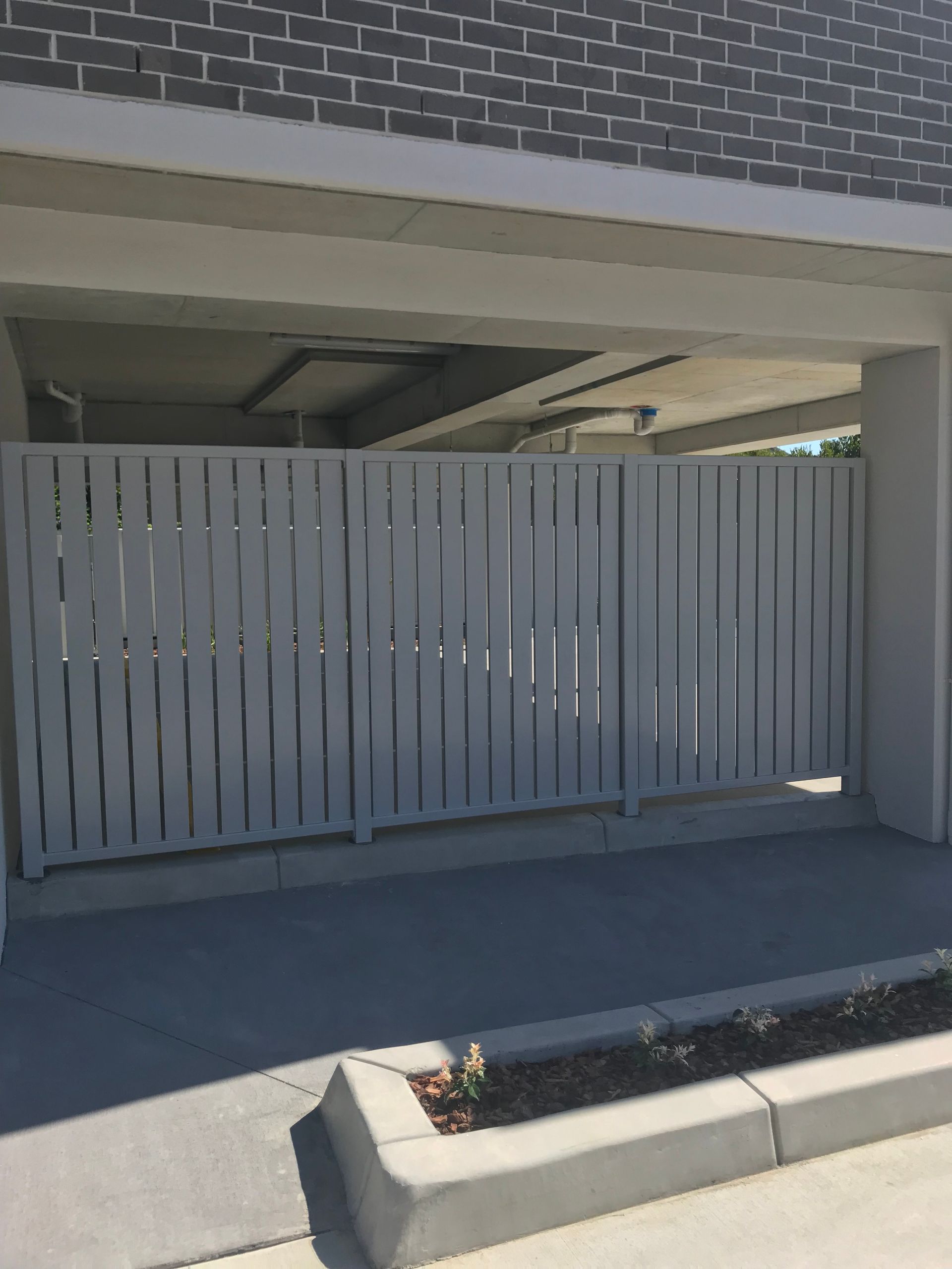 A white fence is in front of a brick building — Fabricator In Coffs Harbour, NSW