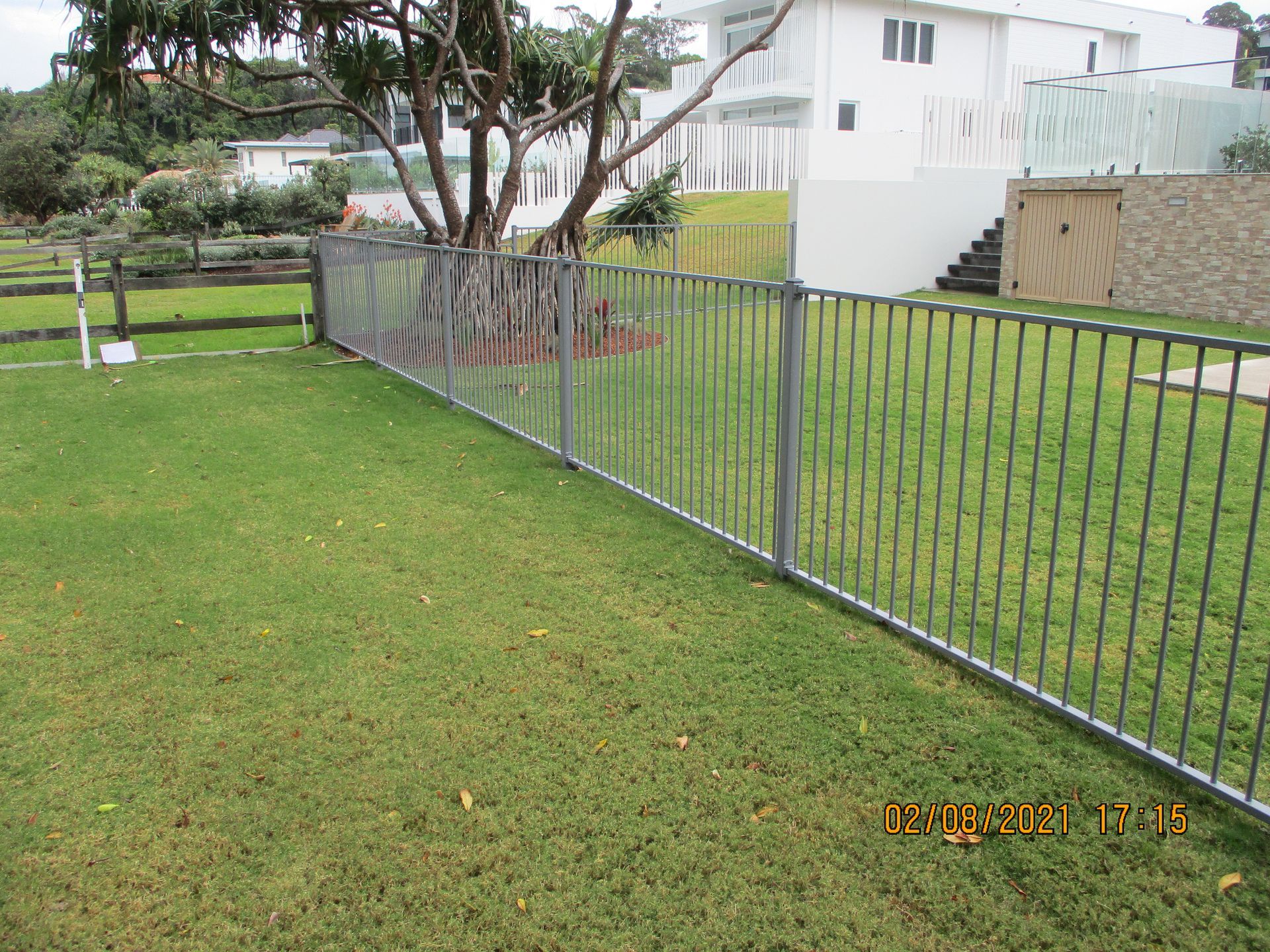 A metal fence surrounds a lush green field — Fabricator In Coffs Harbour, NSW