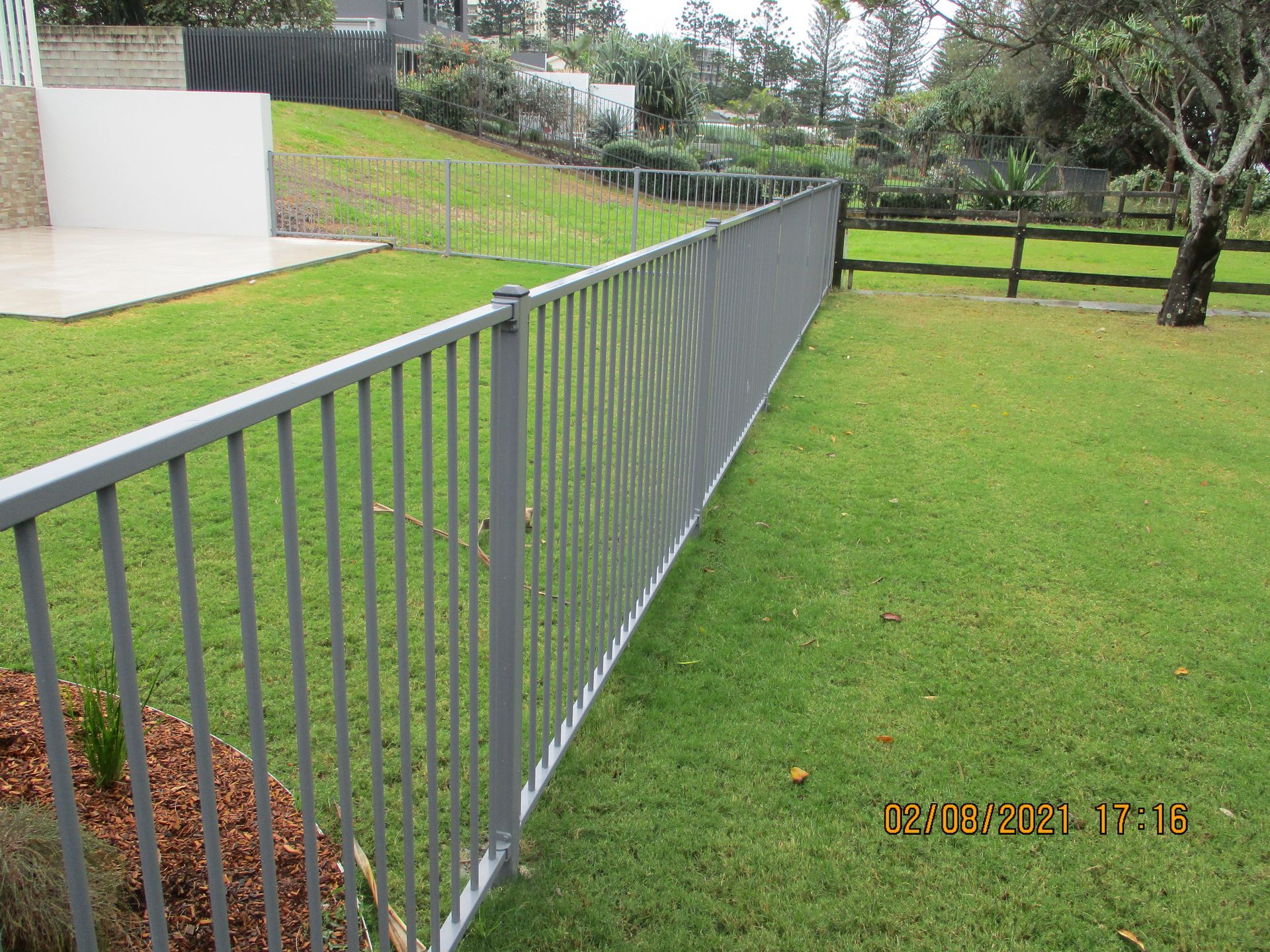 A long metal fence surrounds a lush green field — Fabricator In Coffs Harbour, NSW