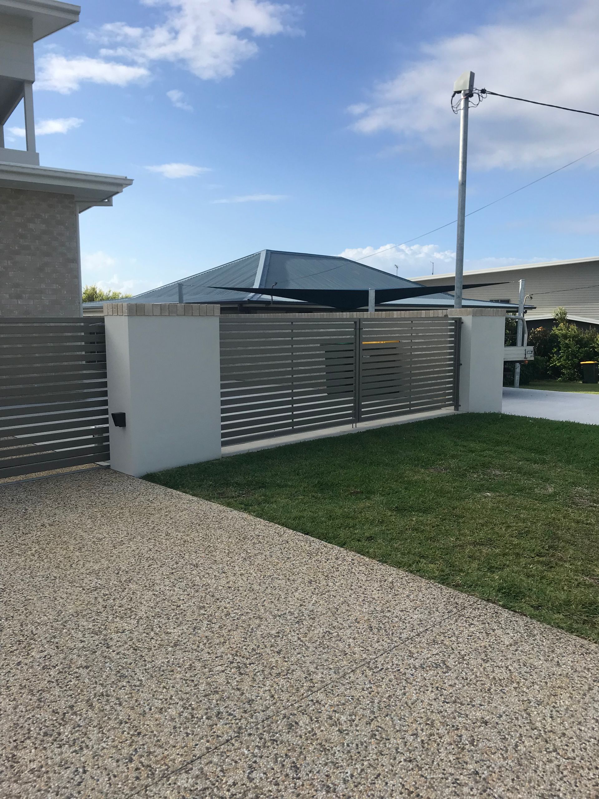 A house with a fence and a gravel driveway in front of it — Fabricator In Coffs Harbour, NSW