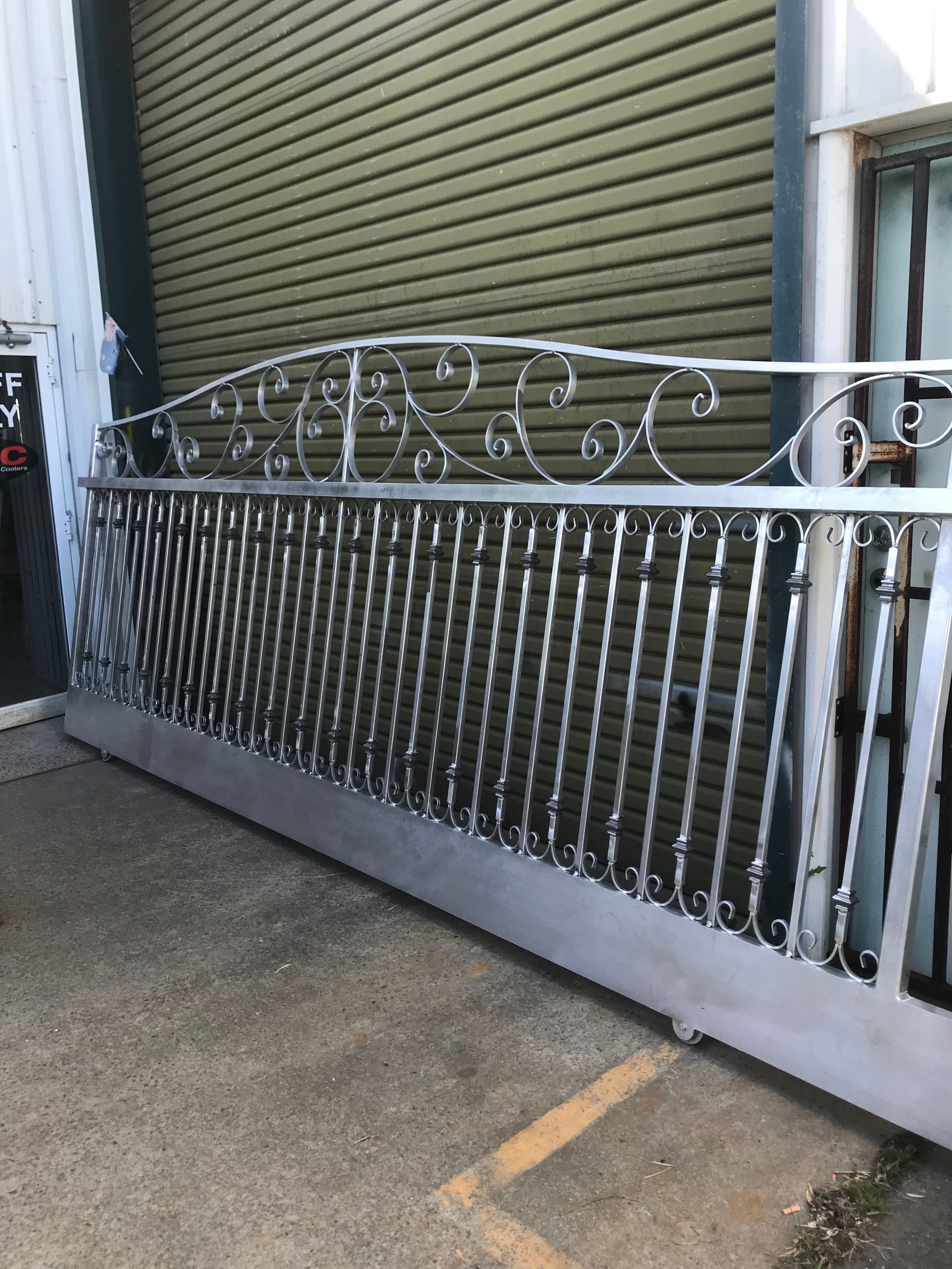 A large metal gate is sitting in front of a building — Fabricator In Coffs Harbour, NSW
