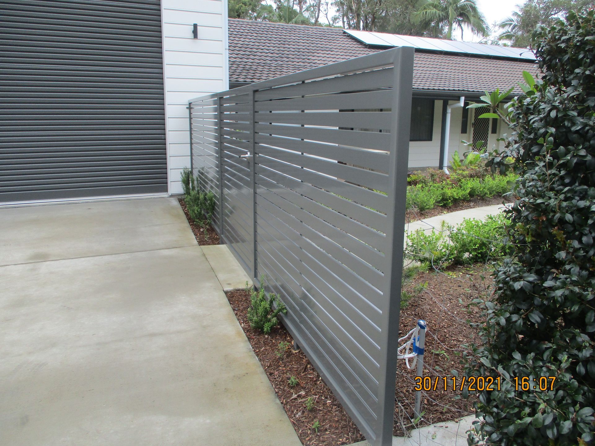 A fence along the side of a driveway in front of a house — Fabricator In Coffs Harbour, NSW