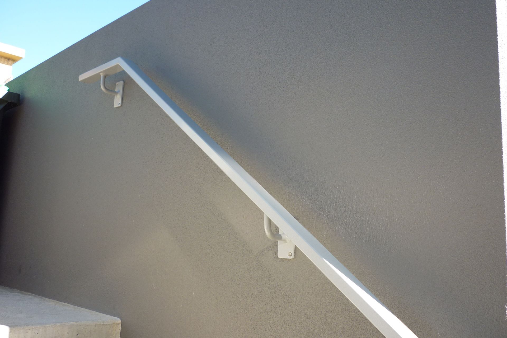A white railing is attached to a gray wall — Fabricator In Coffs Harbour, NSW