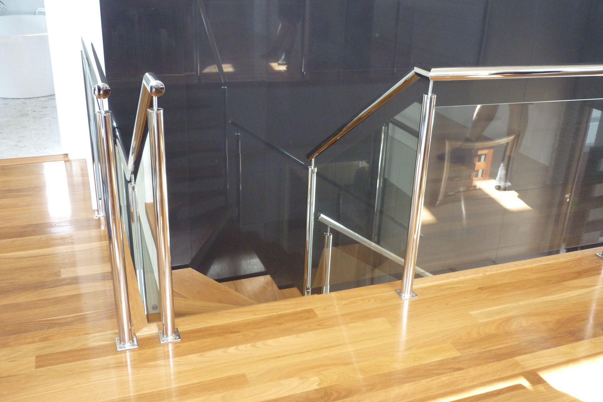A staircase with a glass railing and a wooden floor — Fabricator In Coffs Harbour, NSW