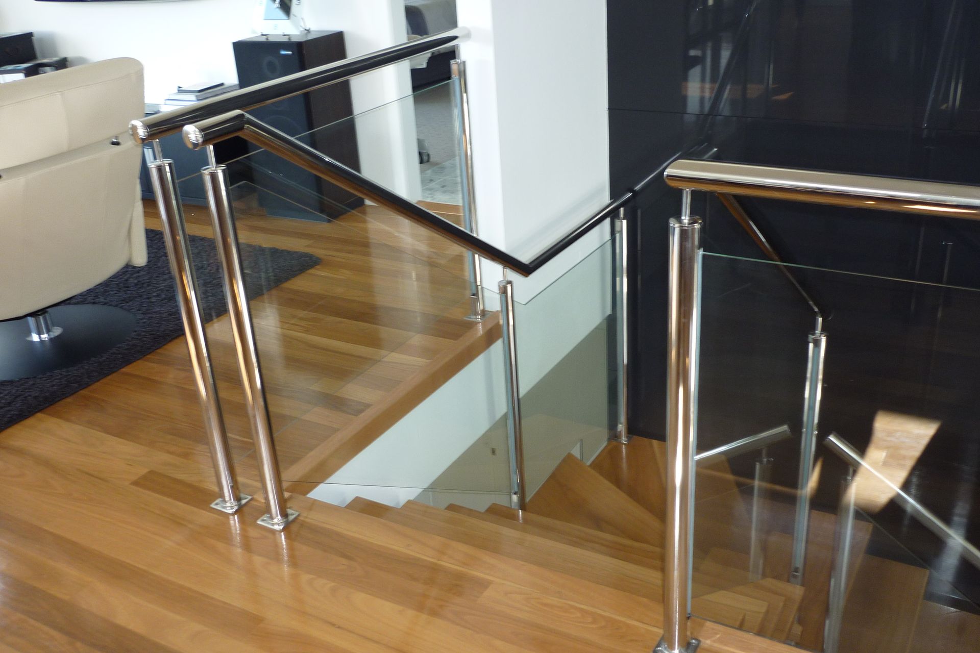 A staircase with a glass railing in a living room — Fabricator In Coffs Harbour, NSW