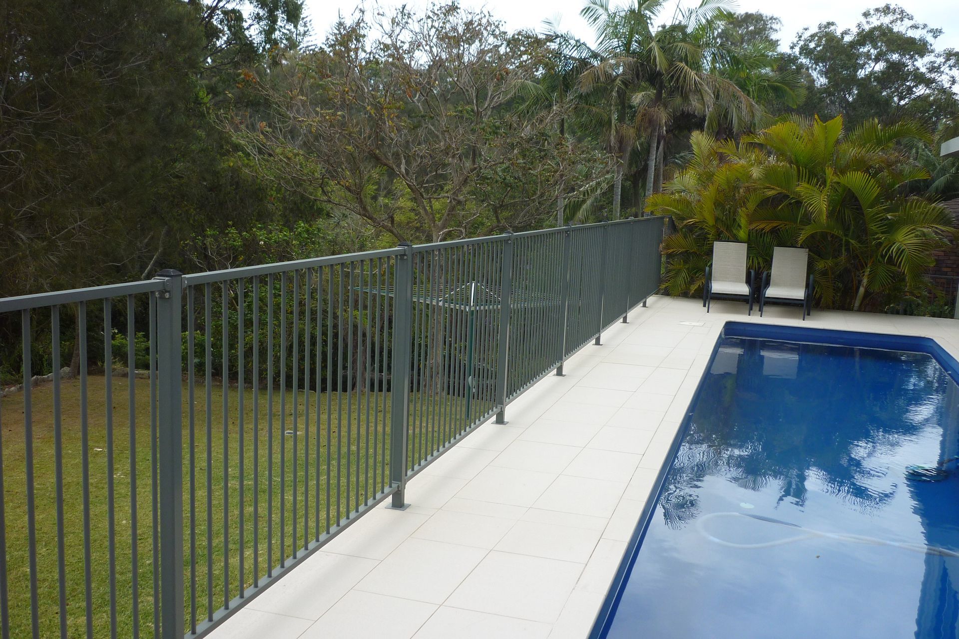A large swimming pool with a fence around it — Fabricator In Coffs Harbour, NSW