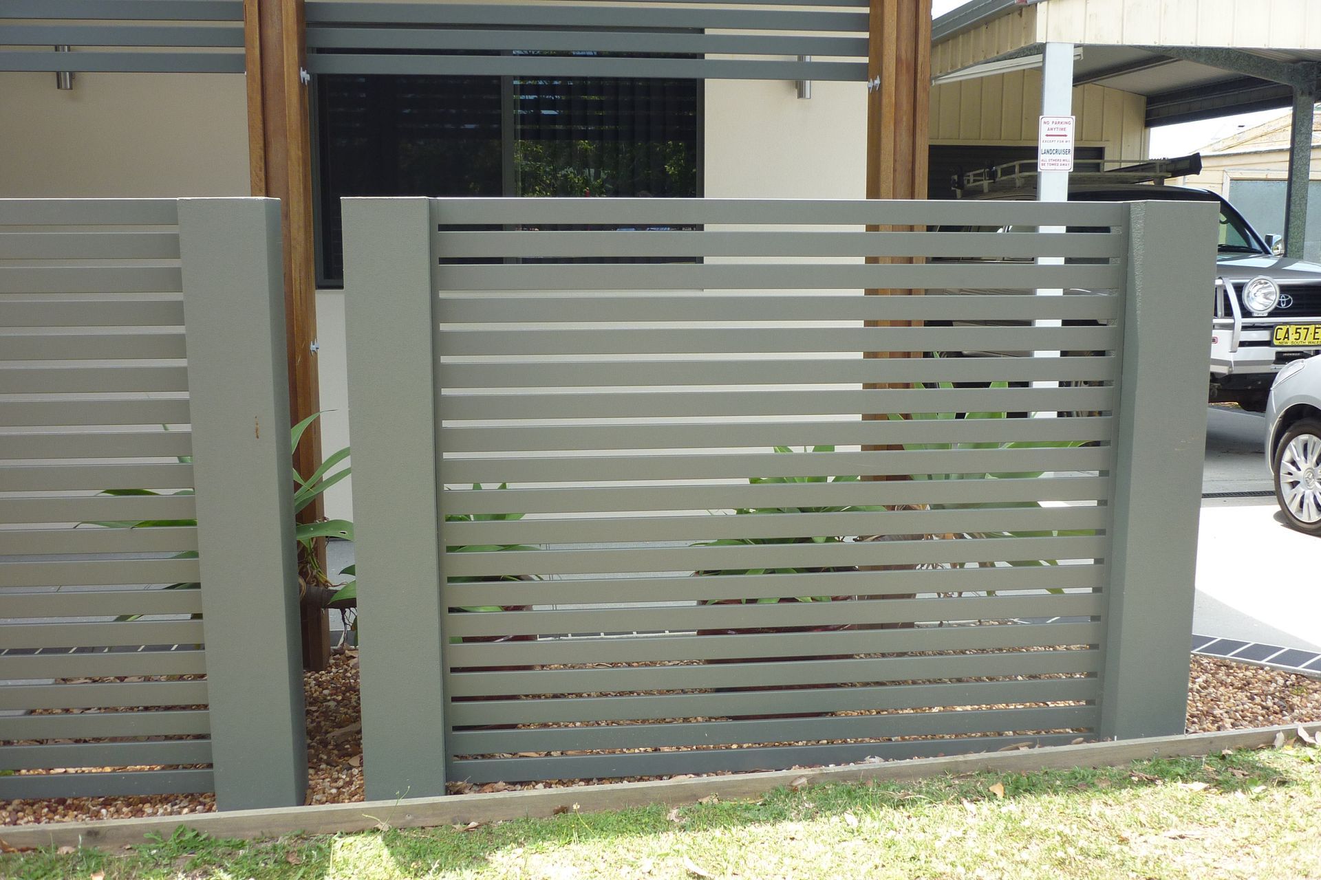 A car is parked behind a fence in front of a house — Fabricator In Coffs Harbour, NSW