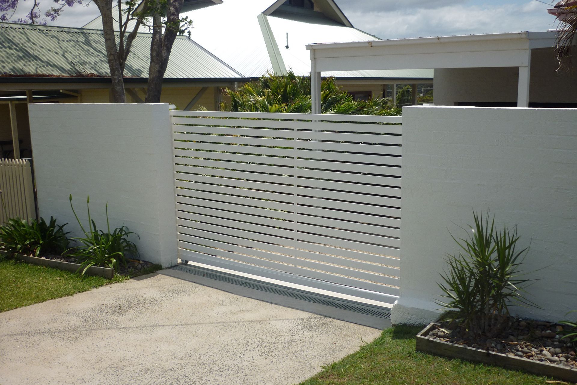 A white fence with a sliding gate in front of a house — Fabricator In Coffs Harbour, NSW
