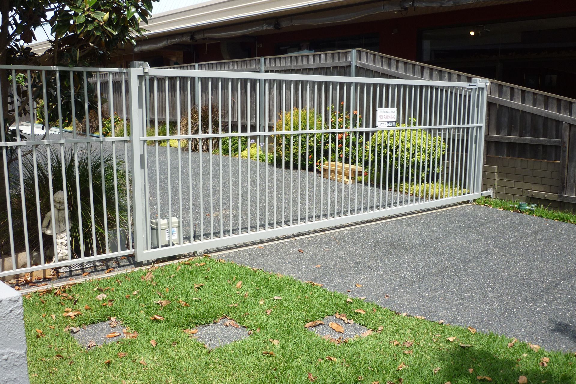 A sliding gate is open in front of a house — Fabricator In Coffs Harbour, NSW