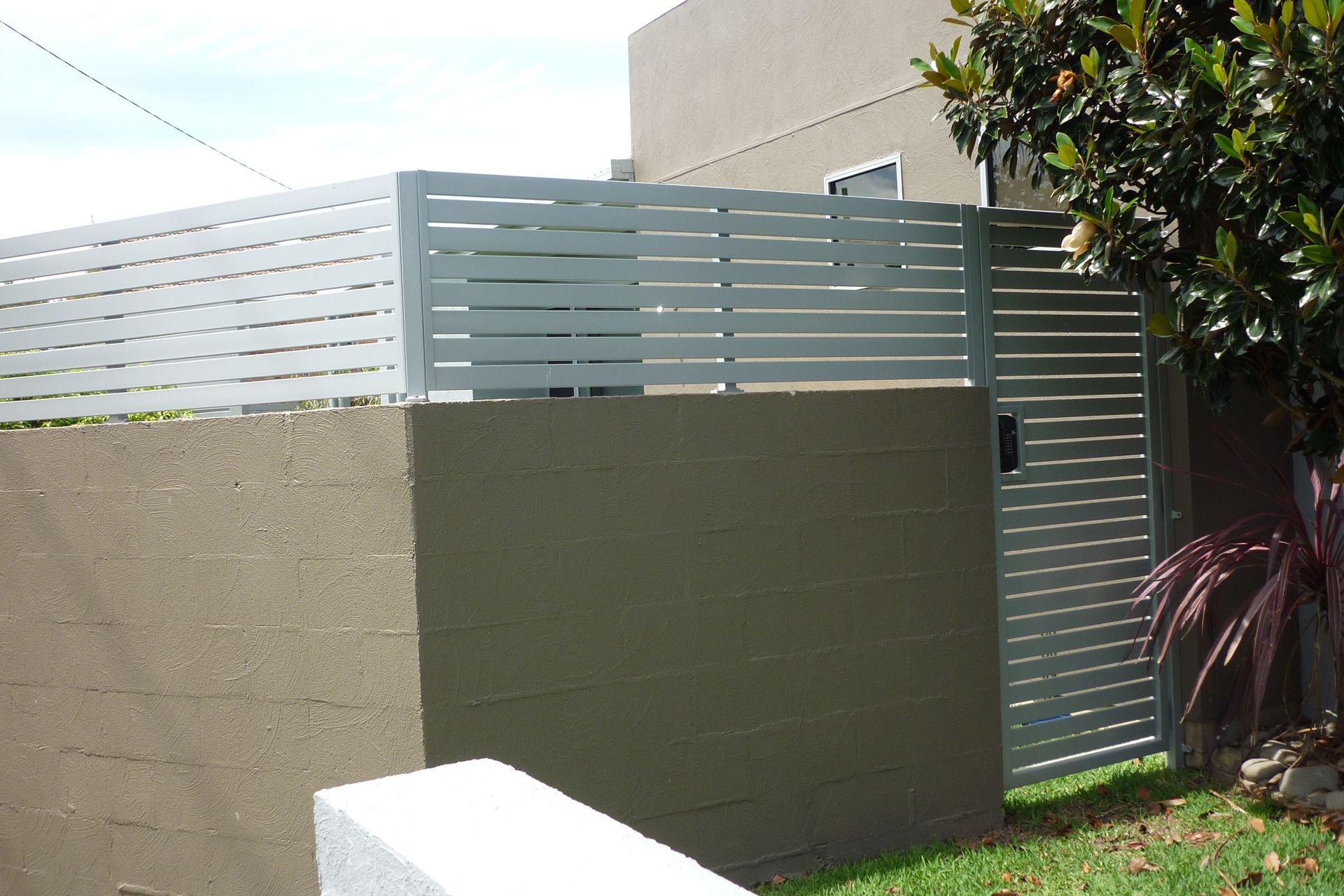A fence with a gate and a tree in the background — Fabricator In Coffs Harbour, NSW