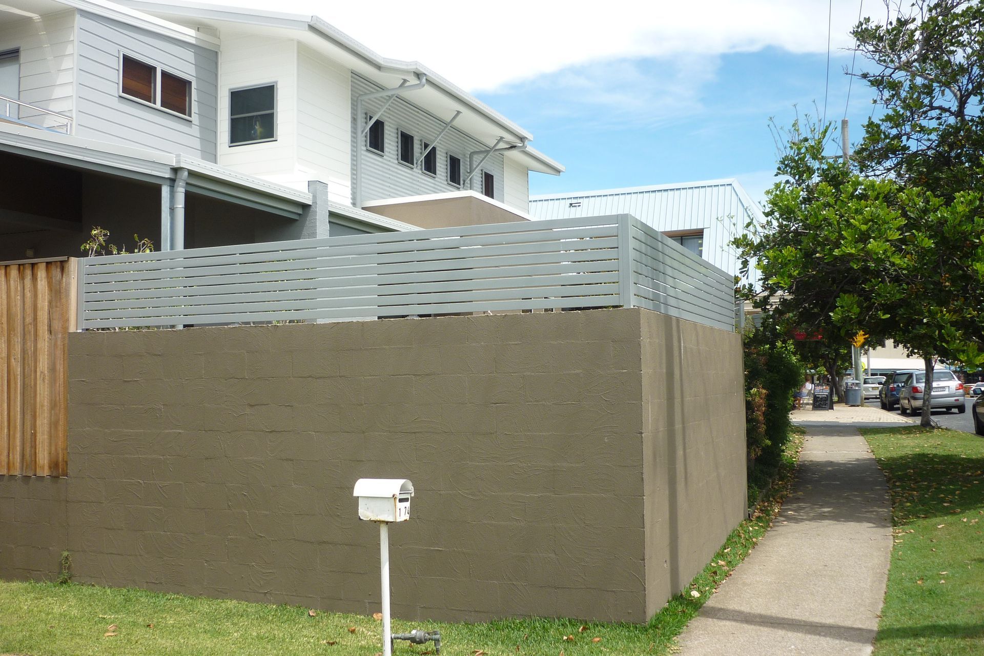A white mailbox in front of a fence with a house in the background — Fabricator In Coffs Harbour, NSW